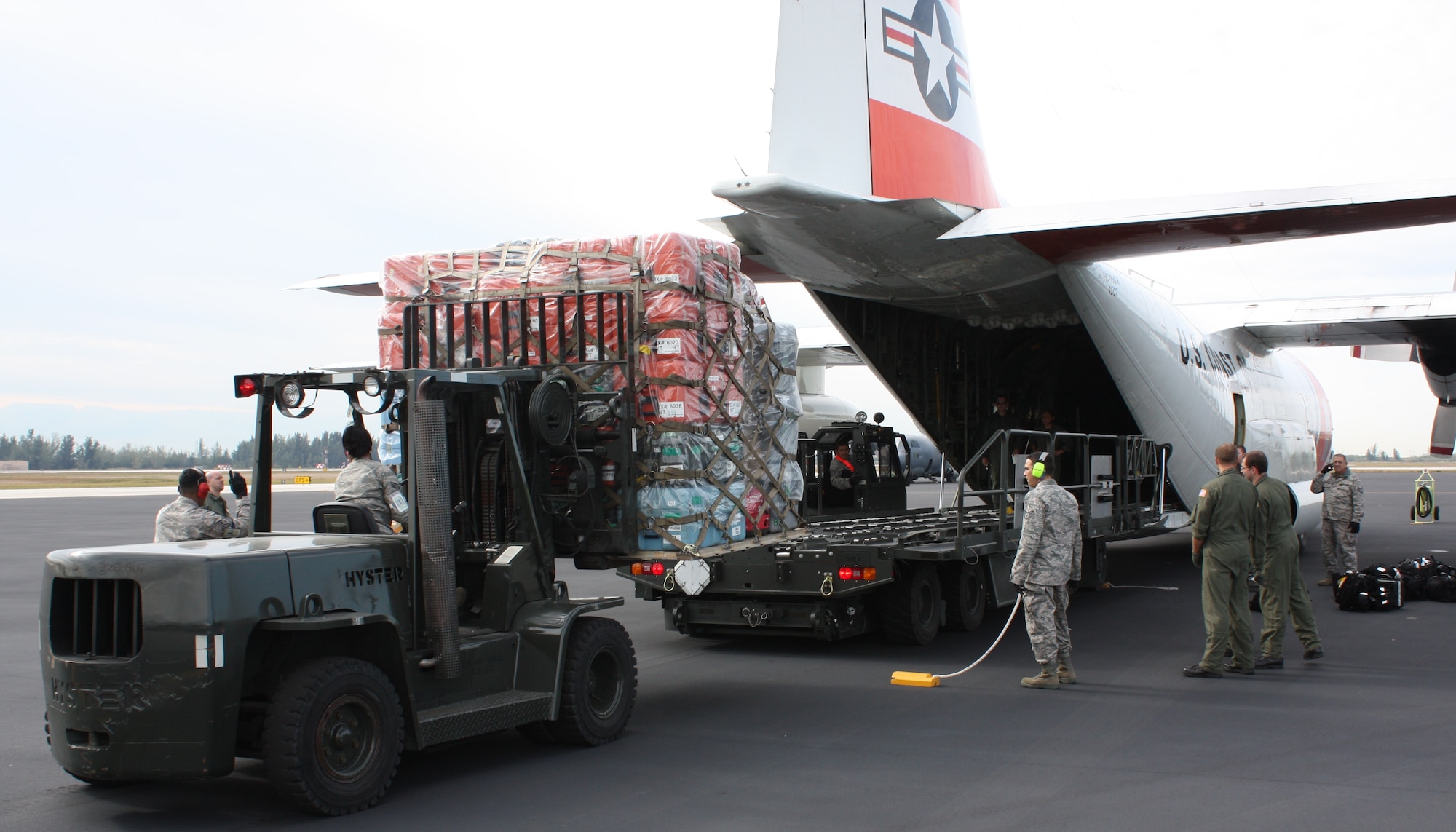 Reservists from the 70th Aerial Port Squadron, load eqipment for the South Florida Urban Search and Rescue FL-TF 2 Team for deployment to Haiti on a U.S Coast Guard C-130 on Jan.14. (U.S. Air Force photo/Ian Carrier)