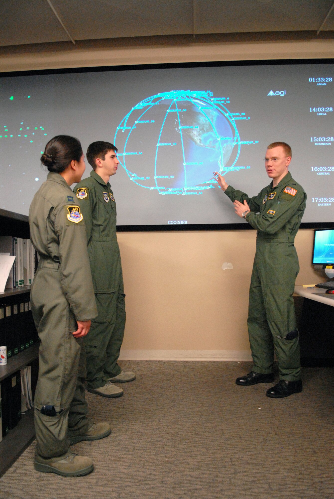 VANDENBERG AIR FORCE BASE, Calif. -- With the tracking system for the Iridium satellite constellation on screen, 1st Lt. Daniel S. Moomey, of the Joint Space Operations Center here, explains his knowledge of how the system works to his coworkers Capt. Amy Ianacone and Airman Patrick Adams Jr., also both with the JSpOC,  here Thursday, Jan. 7, 2010. The Joint Space Operations Center here recently reached a milestone Dec. 18, increasing the number of active satellites tracked from 120 to approximately 1,150. (U.S. Air Force photo/Airman 1st Class Angelina Drake)