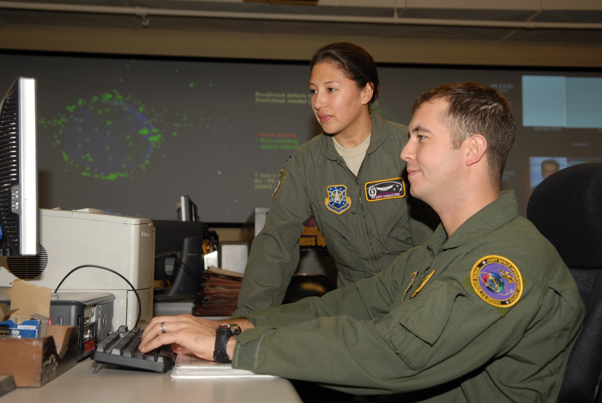 VANDENBERG AIR FORCE BASE, Calif.--  Tracking the status of the Iridium satellite constellation, Staff Sgt. Joe Chestnut, of the Joint Space Operations Center here, presents Capt. Amy Ianacone, also with the JSpOC, with his findings here Thursday, Jan. 7, 2010. The Joint Space Operations Center here recently reached a milestone Dec. 18, increasing the number of active satellites tracked from 120 to approximately 1,150. (U.S. Air Force photo/Airman 1st Class Angelina Drake)