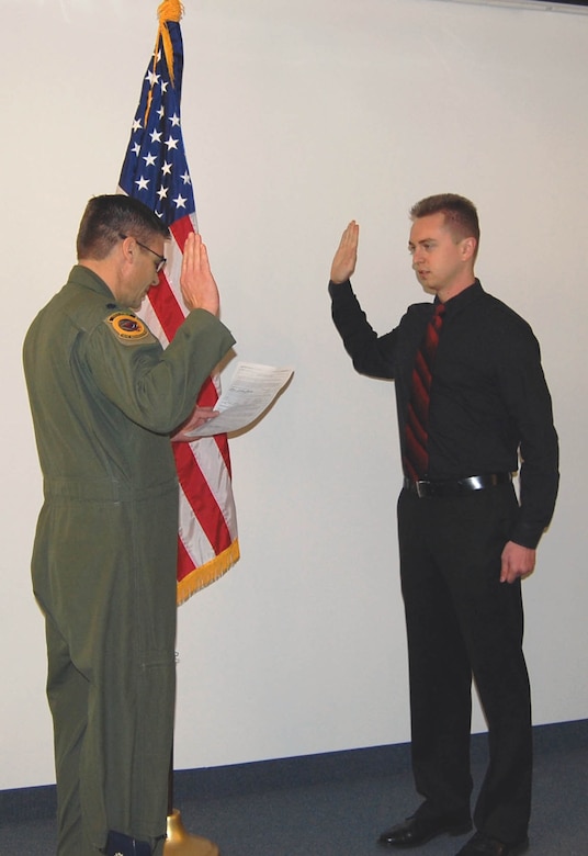 CREECH AIR FORCE BASE, Nev. -- Airman Aaron Jacobson (right) is sworn into the U.S. Air Force by Lt. Col. John Myers, 78th Reconnaissance Squadron commander, during a Unit Training Assembly here on Jan. 13. Airman Jacobson is a Mission Intelligence Coordinator and the squadron's first non-prior service recruit. As a MIC, he supports Remotely Piloted Aircraft combat missions by providing diverse mission coordination with ground forces, collecting target information, and ensuring aircrews understand mission flow and taskings. (U.S. Air Force Reserve photo/Master Sgt. Jennifer Vinson-Perez)