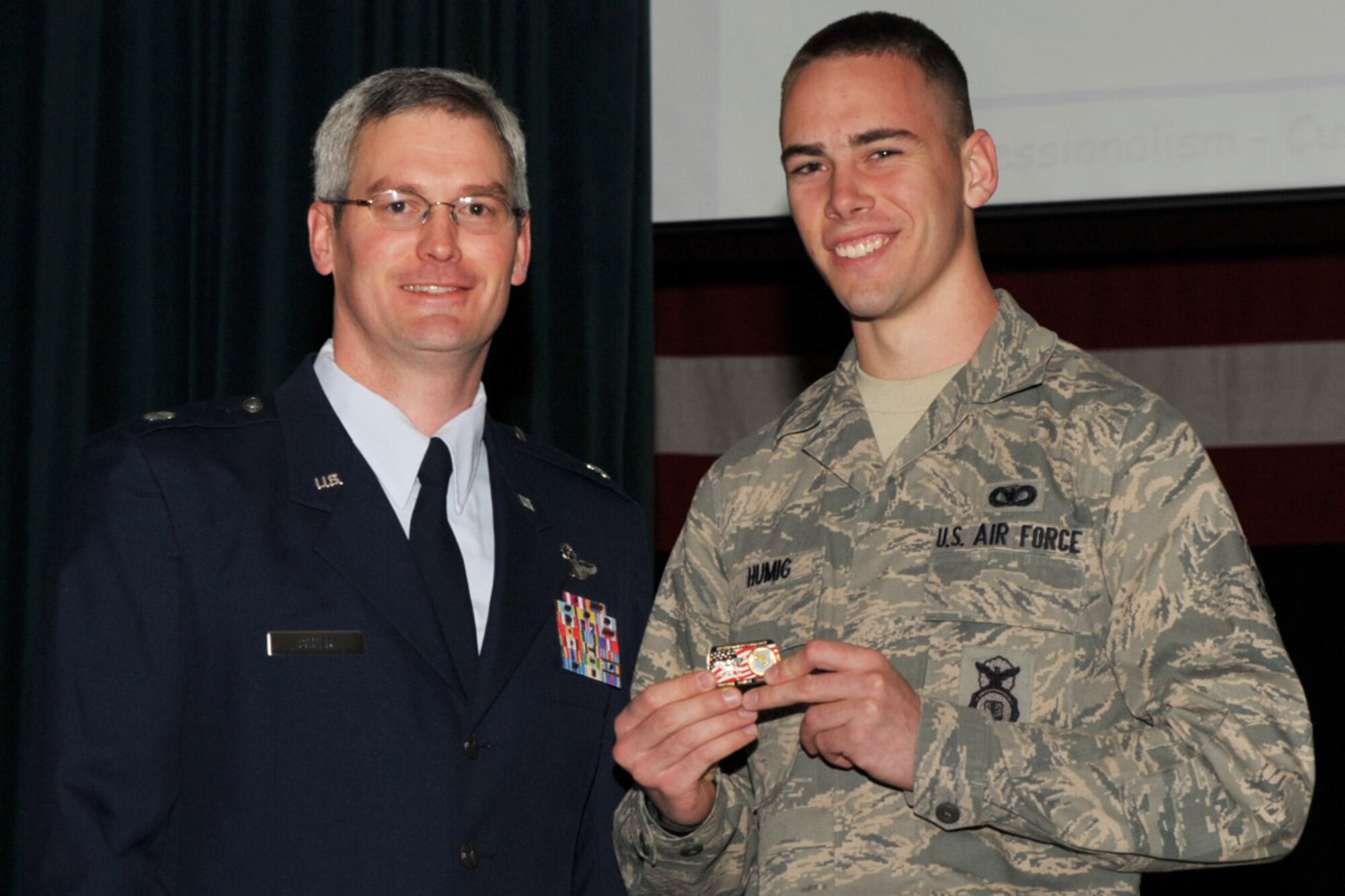 Airman Basic Aaron Humig accepts a commemorative coin during a 931st Air Refueling Group Commander's Call on Jan. 10, 2010. Airman Humig, a Reservist assigned to the 931st Mission Support Flight, was recognized for finishing Air Force basic military training as an honor graduate. Lt. Col. Randy Sauer (on left), 931st ARG acting deputy commander, presented the coin. (U.S. Air Force photo)