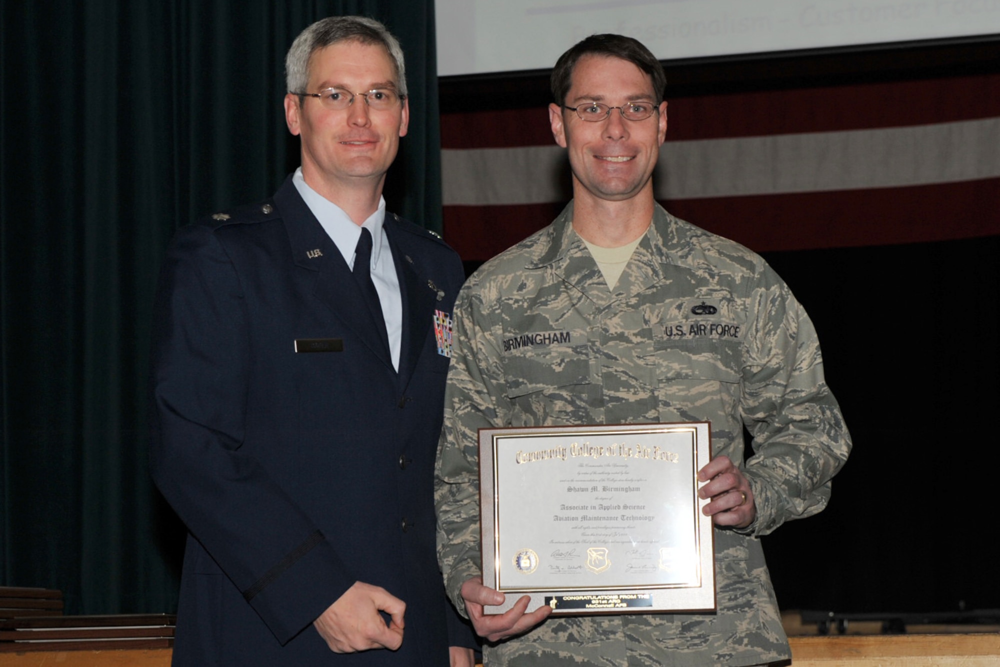 Tech. Sgt. Shawn Birmingham is recognized at McConnell Air Force Base, Kan., for graduating the Community College of the Air Force. Sergeant Birmingham is an Air Force Rerservist assigned to the 931st Aircraft Maintenance Squadron at McConnell. Also pictured is Lt. Col. Randy Sauer, acting deputy commander of the 931st Air Refueling Group. (U.S. Air Force photo)