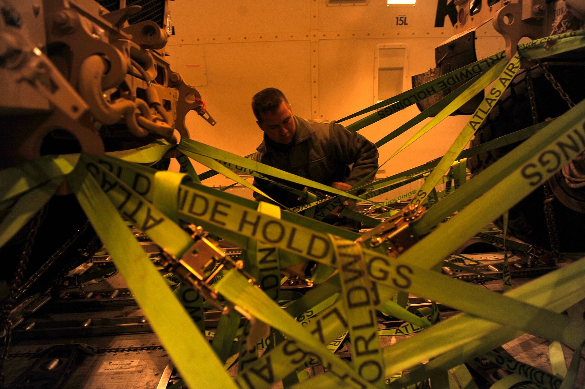 BAGRAM AIRFIELD, Afghanistan-- U.S. Air Force Senior Airman Steven Hansen, 455th Expeditionary Aerial Port Squadron, releases the straps on a Mine Resistant Ambush Protected-All Terrain Vehicles (M-ATV) at Bagram Airfield Jan. 13, 2010.  Hansen is a Reservist stationed Duke Field, Fl. (U.S. Air Force photo by: Tech. Sgt. Jeromy K. Cross)

