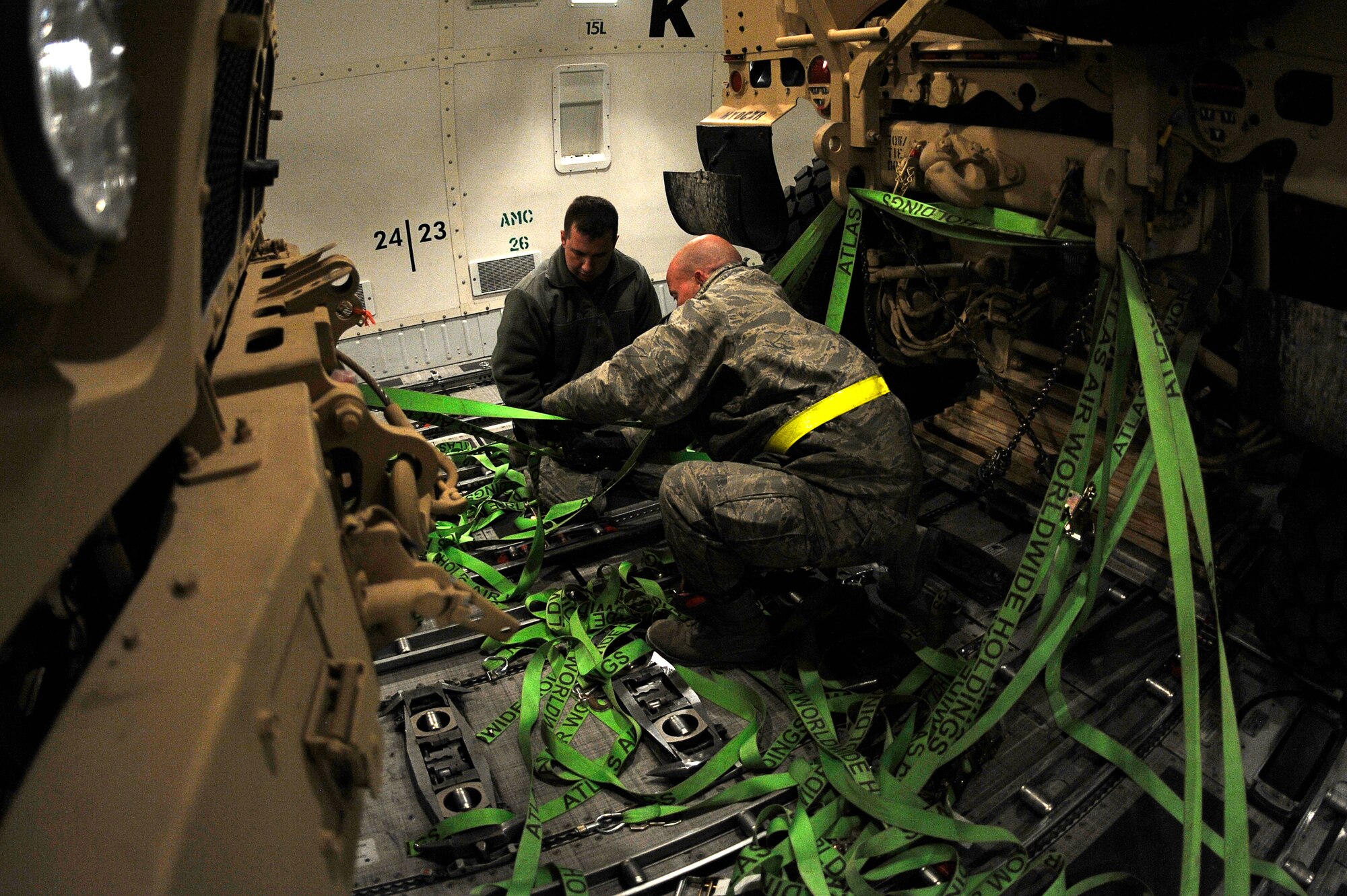 BAGRAM AIRFIELD, Afghanistan-- U.S. Air Force Tech. Sgt. Keith Cloninger (near) and Senior Airman Steven Hansen, 455th Expeditionary Aerial Port Squadron, release the straps on a Mine Resistant Ambush Protected-All Terrain Vehicles (M-ATV) at Bagram Airfield Jan. 13, 2010.  Cloniger is a Reservist from Homestead Fl. Hansen is a Reservist from Duke Field, Fl. (U.S. Air Force photo by: Tech. Sgt. Jeromy K. Cross)
