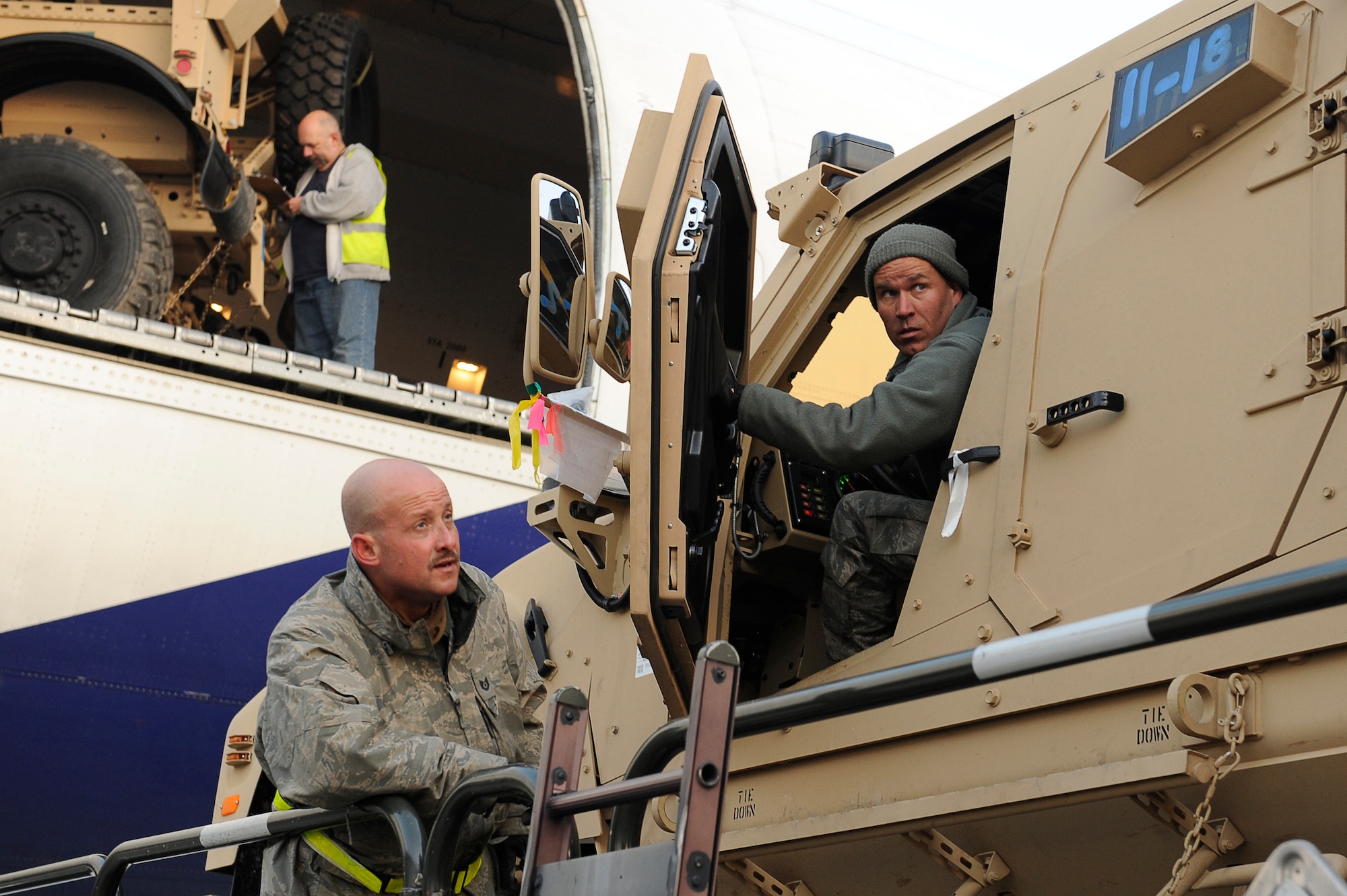 BAGRAM AIRFIELD, Afghanistan-- U.S. Air Force Tech. Sgt. Keith Cloninger (ground) and Tech Sgt. Mark Forman, 455th Expeditionary Aerial Port Squadron, use a 25K Loader to off load a Mine Resistant Ambush Protected-All Terrain Vehicles (M-ATV) at Bagram Airfield Jan. 13, 2010.  Cloniger is a Reservist from Homestead Fl. Forman is stationed Lackland Air Force Base, Texas and is from San Antonio, Texas. (U.S. Air Force photo by: Tech. Sgt. Jeromy K. Cross)