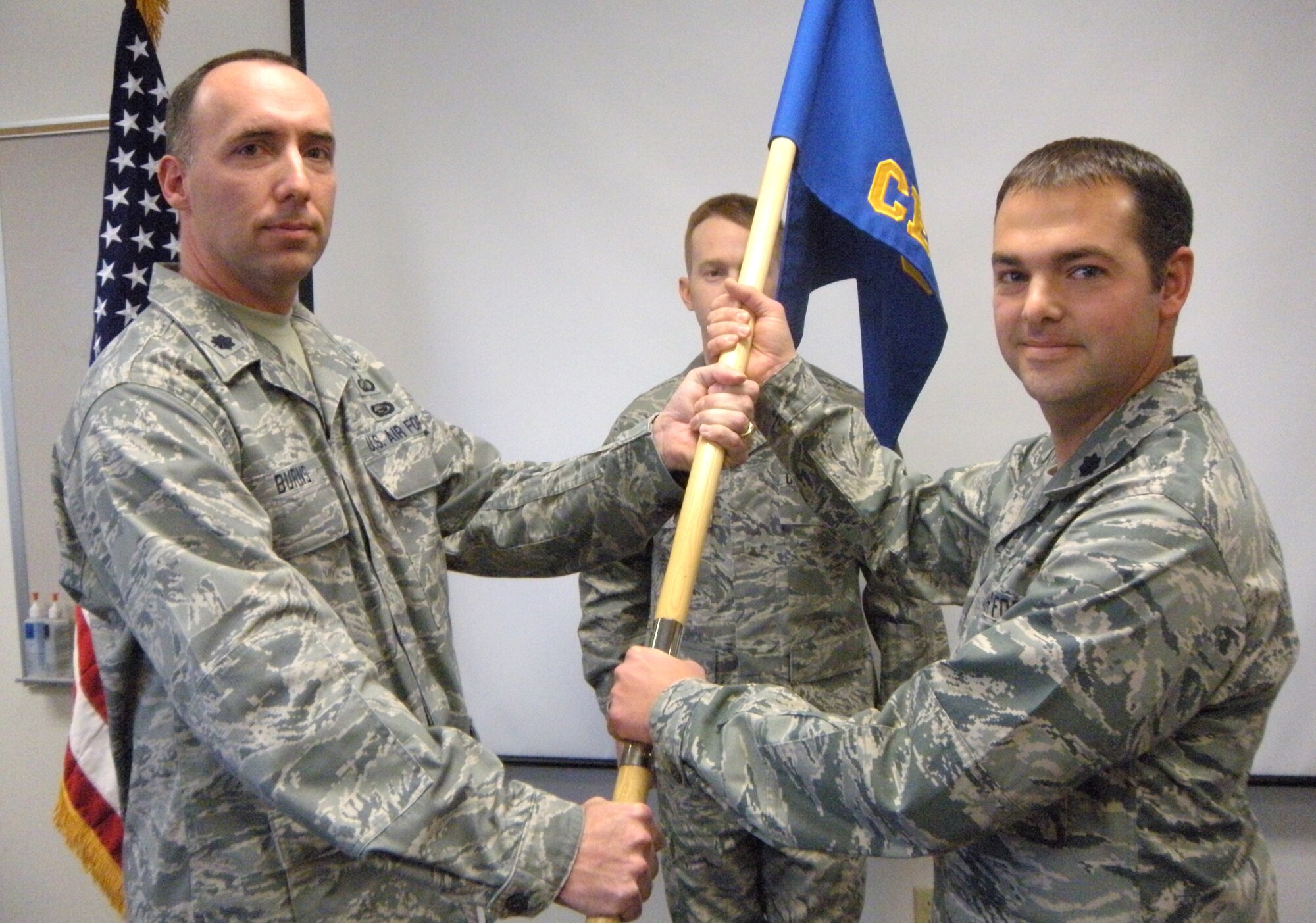 Lt. Col. Brian Brech (right) accepts the 302nd Civil Engineer Squadron guidon from Lt. Col. Michael Burns (left) Jan. 9 during a change of command ceremony at Peterson Air Force Base, Colo. Colonel Brech, with the squadron's first sergeant, Master Sgt. Matthew Youkey behind him, accepted command of the 302nd CES, a unit that recently returned from a six-month deployment supporting Operation Iraqi Freedom. Colonel Burns is the commander of the 302nd Mission Support Group. (U.S. Air Force photo/Tech. Sgt. Stephanie Bonnin)