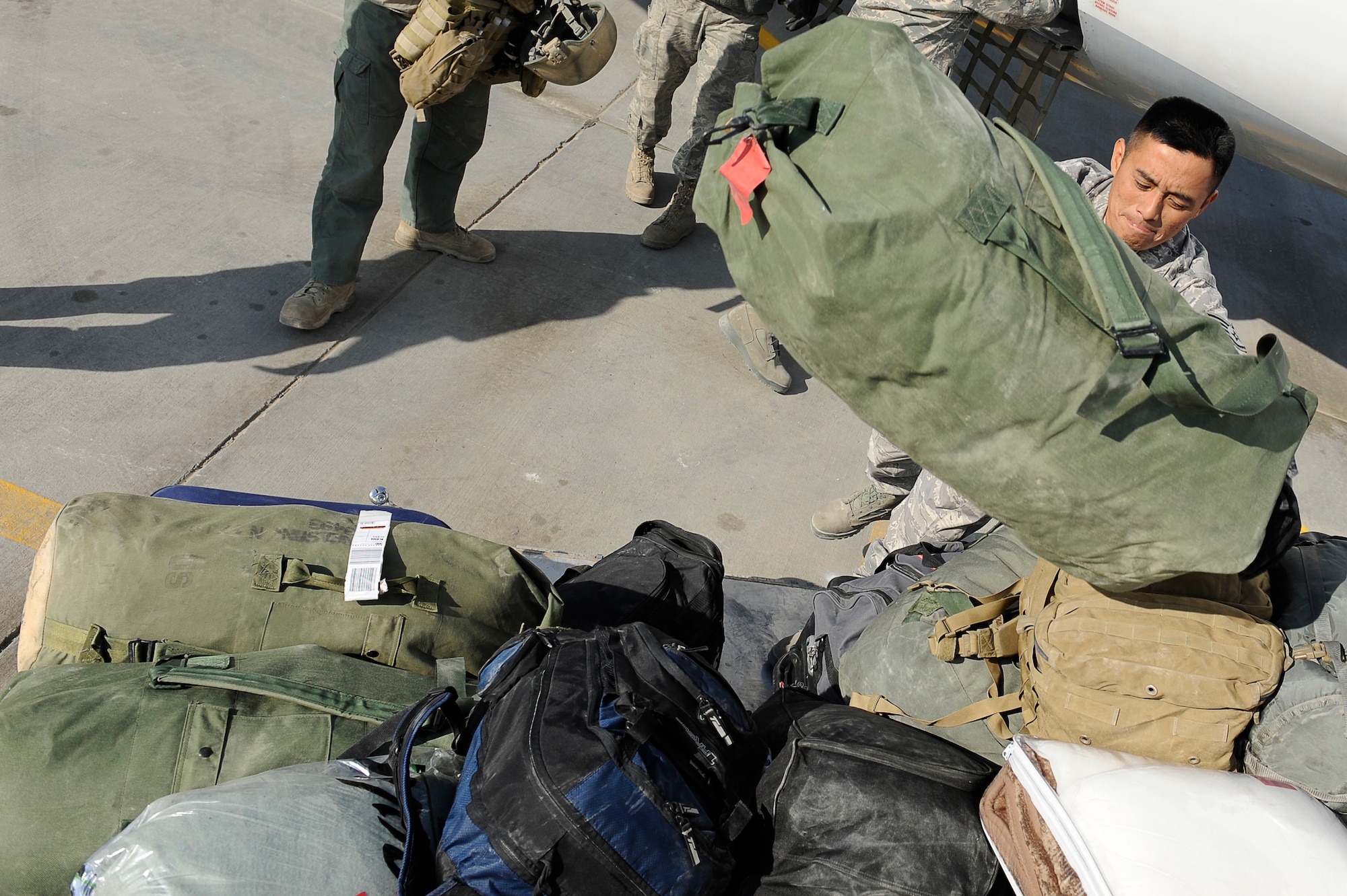 BAGRAM AIRFIELD, Afghanistan-- U.S. Air Force Staff Sgt. Alex Santiago, 455th Expeditionary Aerial Port Squadron, unloads an aircraft at Bagram Airfield, Afghanistan, Jan.12, 2010.  Santiago is a Reservist from Carlos Heights, Guam. (U.S. Air Force photo by: Tech. Sgt. Jeromy K. Cross)