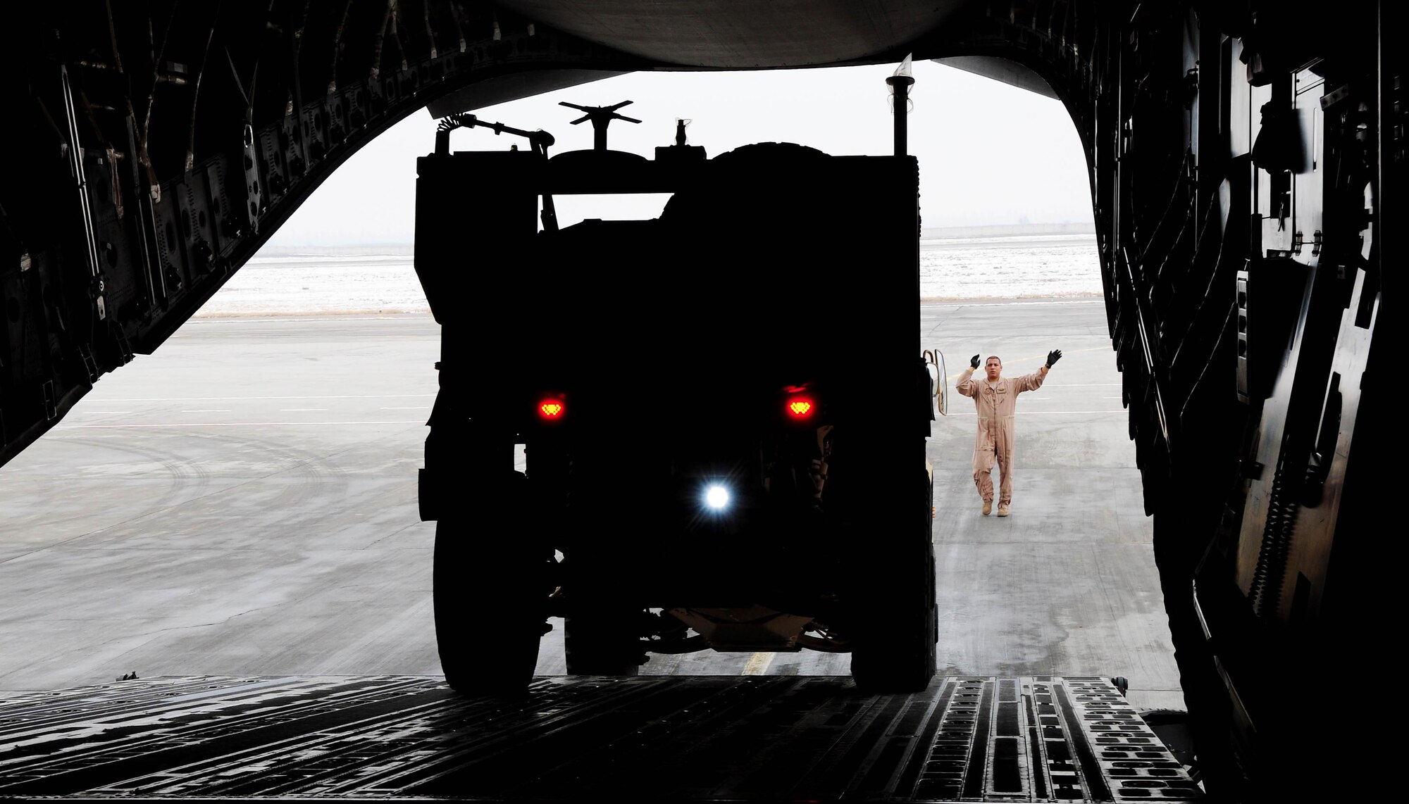 TRANSIT CENTER AT MANAS, Kyrgyzstan - Tech. Sgt. Antonio Mu?oz, NCOIC and instructor loadmaster from the Transit Center?s C-17 detachment, guides an MRAP-all terrain vehicle into a C-17 Globemaster III prior to shipment to Afghanistan. The new M-ATVs are better equipped to withstand current combat conditions. Several C-17s provide airlift for military servicemembers and cargo. (U.S. Air Force photo by Senior Airman Nichelle Anderson)