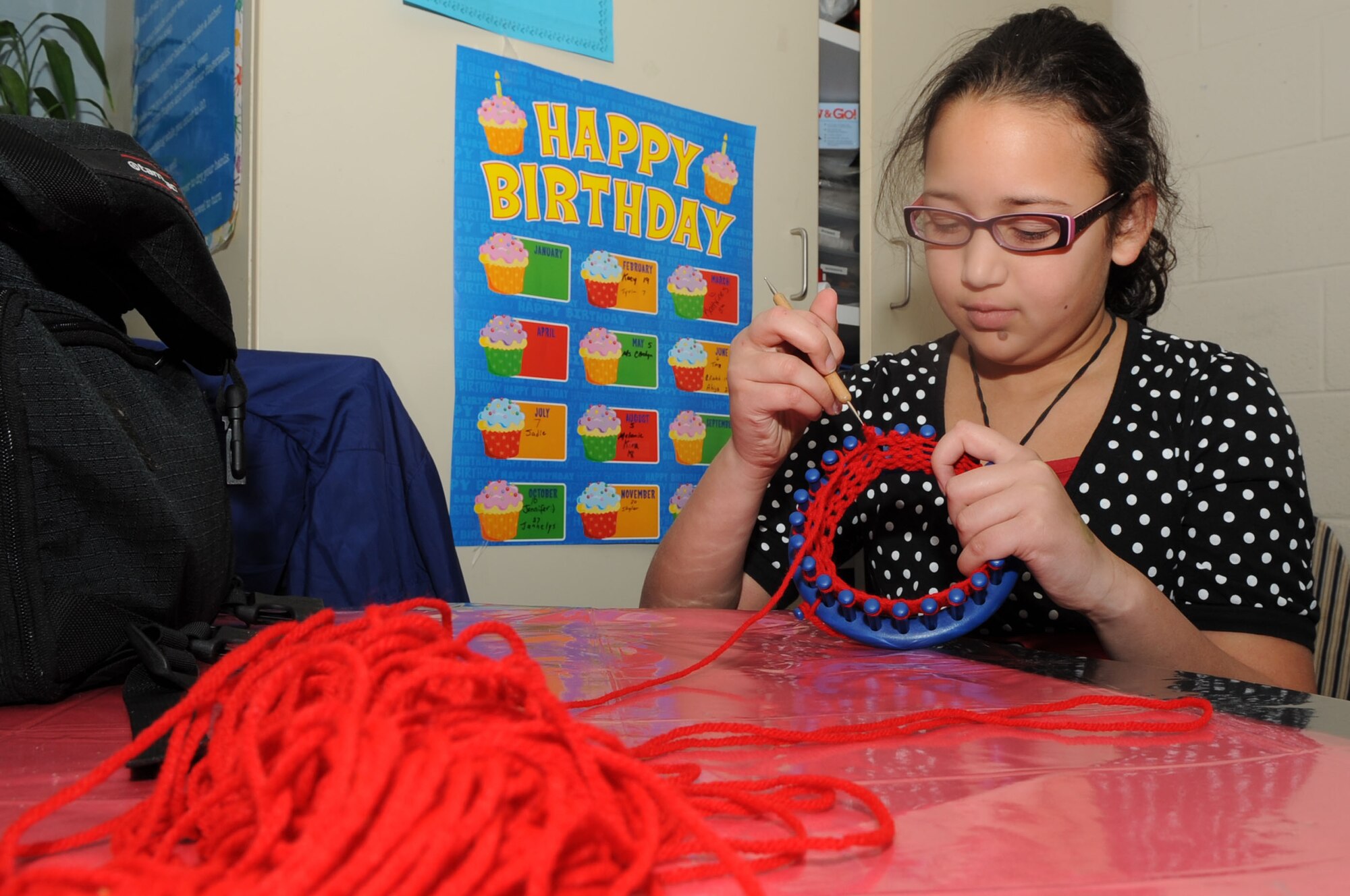Sadie Chandler, 9 years old, uses a loom to make a knit hat at the youth center on Seymour Johnson Air Force Base, N.C., Jan. 12, 2010. The children in the school-age program knitted multi-colored hats in a variety of sizes, because no two babies have the same size head. Sadie is the daughter of Master Sgt. Keri Chandler, 4th Medical Group NCOIC of deployment medicine. (U.S. Air Force photo/Staff Sgt. Courtney Richardson)
