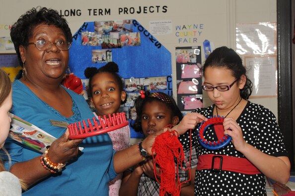 Carolyn Artis, youth center school-age program assistant, explains the purpose of a loom as Sadie Chandler, 9 years old, demonstrates how to use it at the youth center on Seymour Johnson Air Force Base, N.C., Jan. 12, 2010. Looms come in a variety of sizes and shapes, including round, oval, and rectangular. Sadie is the daughter of Master Sgt. Keri Chandler, 4th Medical Group NCOIC of deployment medicine. (U.S. Air Force photo/Staff Sgt. Courtney Richardson)