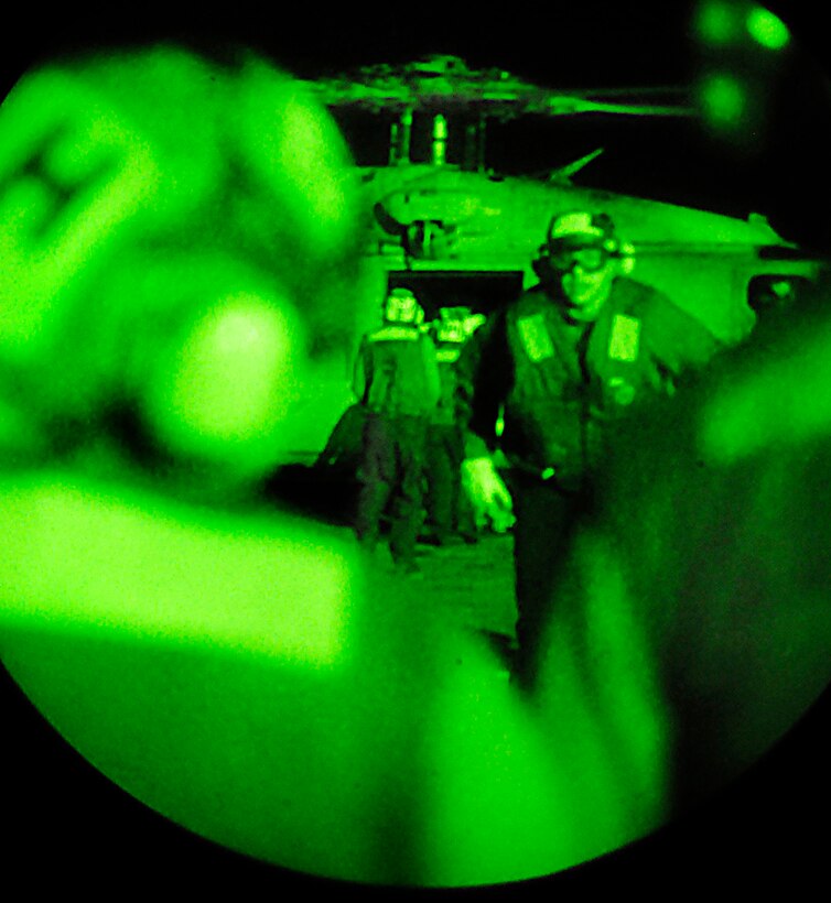 As seen through a night-vision device, U.S. sailors aboard aircraft carrier USS Carl Vinson transfer supplies to the ship from an SH-60F Seahawk helicopter from Helicopter Anti-Submarine Squadron 15 in the Atlantic Ocean, Jan. 13, 2010. The Carl Vinson and Carrier Air Wing 17 have received orders from U.S. Southern Command to provide humanitarian assistance to the Caribbean nation of Haiti, following a 7.0-magnitude earthquake, Jan. 12, 2010.