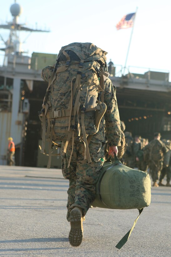 Seabag in hand and rucksack on his back, a Marine from the 22nd Marine Expeditionary Unit heads toward the amphibious assault ship Bataan at the Morehead City, N.C. port, Jan. 15, 2009.  The 22nd MEU will deploy aboard the Bataan and the USS Carter Hall and Fort McHenry to the earthquake-ravaged Caribbean nation of Haiti to conduct sea-based humanitarian assisstance and disaster relief.