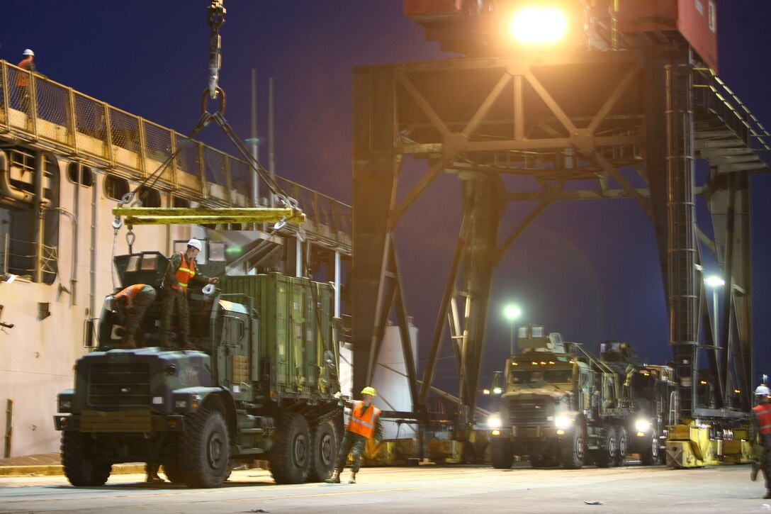 Working into the night, logisticians from the 22nd Marine Expeditionary Unit prepare vehicles to be winched onto amphibious assault ships at the Morehead City, N.C. port, Jan. 15, 2010.  The 22nd MEU will deploy to the earthquake-ravaged Caribbean nation of Haiti aboard the USS Bataan, Carter Hall and Fort McHenry to conduct sea-based humanitarian assisstance and disaster relief.