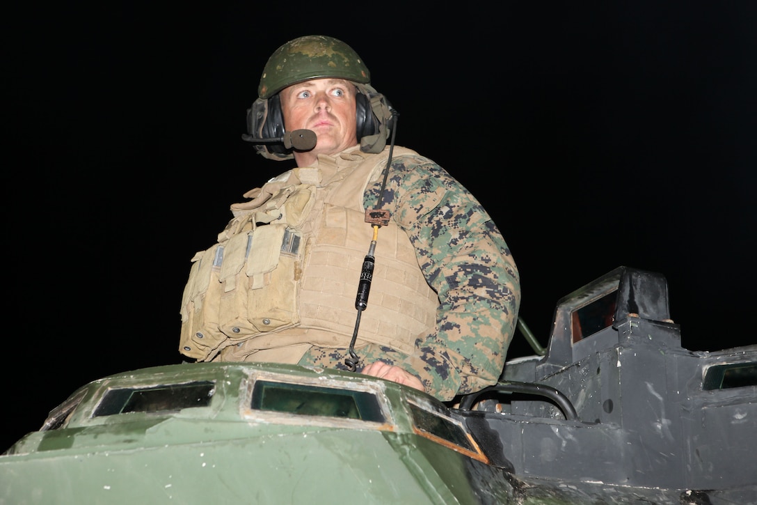 The commander of an assault amphibian vehicles waits for the order to enter the Atlantic Ocean off Onslow Beach aboard Camp Lejeune, N.C., Jan. 16, 2010.  A platoon of AAVs left Camp Lejeune in the pre-dawn hours to join the 22nd Marine Expeditionary embarked aboard the Bataan Amphibious Ready Group as it prepares to deploy to the Caribbean island nation of Haiti to provide sea-based disaster relief and humanitarian assistance in the wake of an earthquake that devestated the country on Jan. 12.