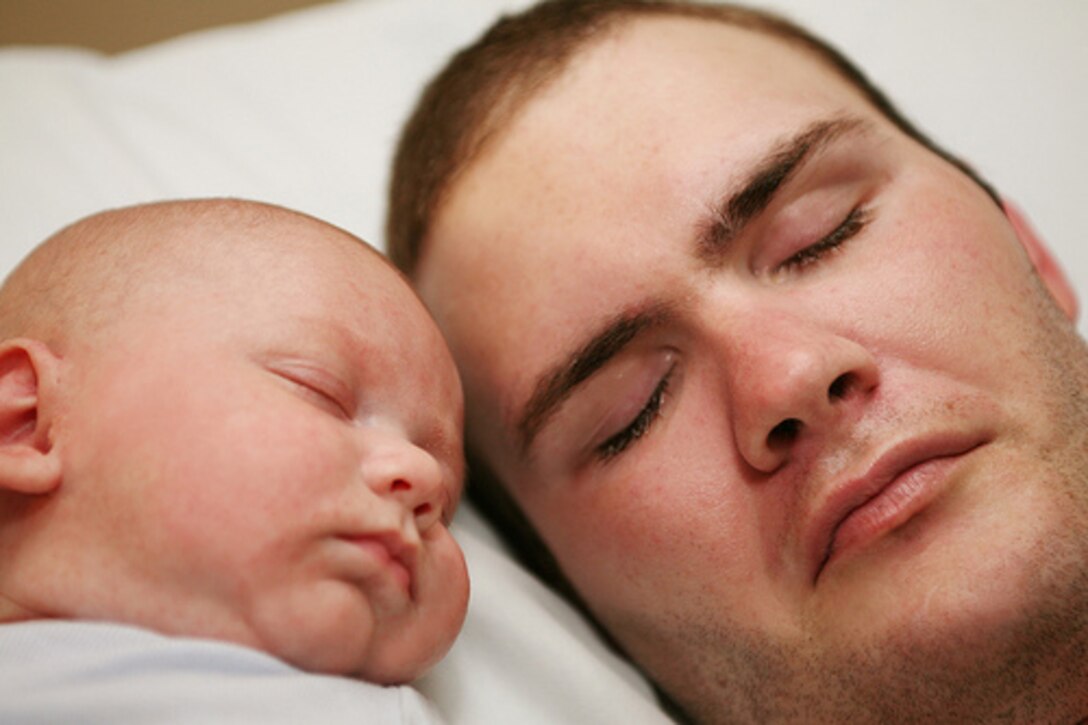 In this undated family photo, Petty Officer 2nd Class Anthony Thompson, a hospital corpsman with 2nd Battalion, 7th Marine Regiment, lays with his young son, A.J. Thompson was seriously wounded by a vehicle-borne improvised explosive device during his second deployment to Iraq in 2007 with 2nd Bn., 7th Marines. The organization Homes for Our Troops, which specializes in building specialized homes for seriously wounded veterans at no cost, started building a home for him, his wife, Ivonne, and AJ Jan. 8. The house was built up from a concrete slab into a weather-tight structure in a three-day build brigade. The house will be completed in four to six months.