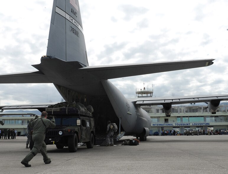 C-130J loadmasters from the 41st Airlift Squadron rapidly deploy a Humvee and equipment during an engine running off-load at the Port-au-Prince International Airport, Haiti, Jan. 14 as part of on-going Haitian earthquake relief operations. The equipment and personnel departing delivered by the C-130J aircrew from Little Rock Air Force Base, Ark., will be used for conducting an airfield assessment in support of the earthquake relief in Haiti.  (USAF Photo by Staff Sgt. Chad Chisholm) (Cleared by Mr. Arlo Taylor, 19th Airlift Wing Public Affairs)