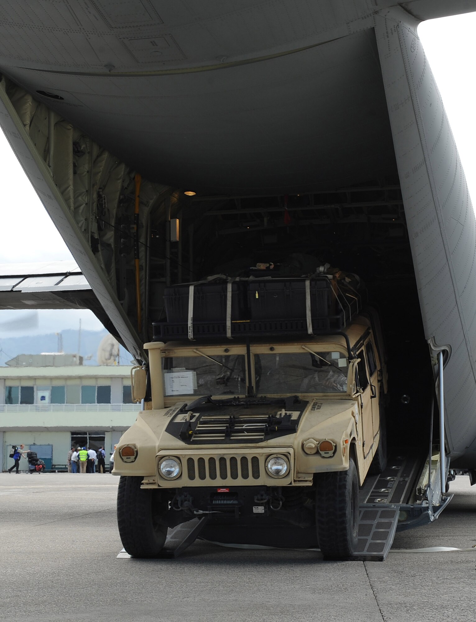 A Humvee is rapidly deployed from a 41st Airlift Squadron C-130J during an engine running off-load at the Port-au-Prince International Airport, Haiti, Jan. 14 as part of ongoing Haitian earthquake relief operations. The equipment and personnel delivered by the aircrew from Little Rock Air Force Base, Ark., will be used for conducting an airfield assessment in support of the earthquake relief in Haiti.  (USAF Photo by Staff Sgt. Chad Chisholm) (Cleared by Mr. Arlo Taylor, 19th Airlift Wing Public Affairs)