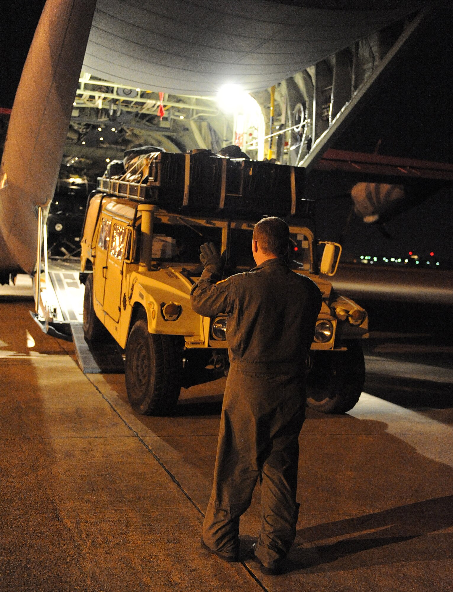 Staff Sgt. Lynzey Thorton, 41st Airlift Squadron Loadmaster, guides a Humvee into the back of a C-130J Jan. 14 at the Biloxi-Gulfport International Airport, Miss., as part of their mission to deliver equipment and personnel to support the Haitian relief effort. The aircraft launched from Little Rock Air Force Base, Ark., near midnight Jan. 13, loaded personnel and equipment before dawn Jan. 14 at Biloxi-Gulfport International Airport, Miss., and delivered them the morning of Jan. 14 as part of on-going Haitian relief efforts.  (USAF Photo by Staff Sgt. Chad Chisholm) (Cleared by Mr. Arlo Taylor, 19th Airlift Wing Public Affairs)