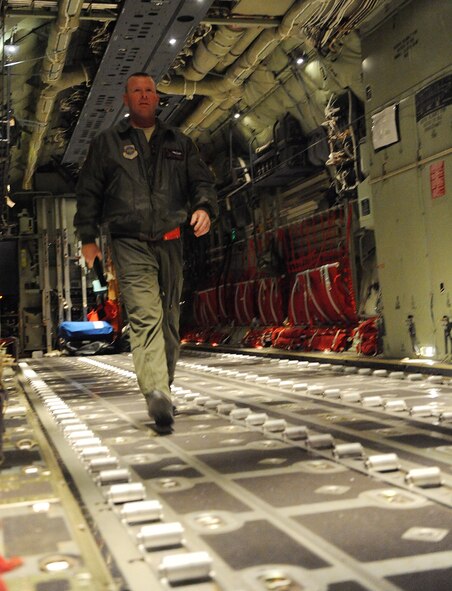 Technical Sgt. Charles Moore, 41st Airlift Squadron loadmaster, walks to the back of a C-130J during a pre-flight check Jan. 13 before the aircraft's mission to deliver equipment and personnel to support the Haitian relief effort. The aircraft launched from Little Rock Air Force Base, Ark., near midnight Jan. 13, loaded personnel and equipment before dawn at Biloxi-Gulfport International Airport, Miss., and delivered them to the Port-au-Prince International Airport, Haiti, the morning of Jan. 14 as part of on-going Haitian relief efforts. (USAF Photo by Staff Sgt. Chad Chisholm) (Cleared by Mr. Arlo Taylor, 19th Airlift Wing Public Affairs)