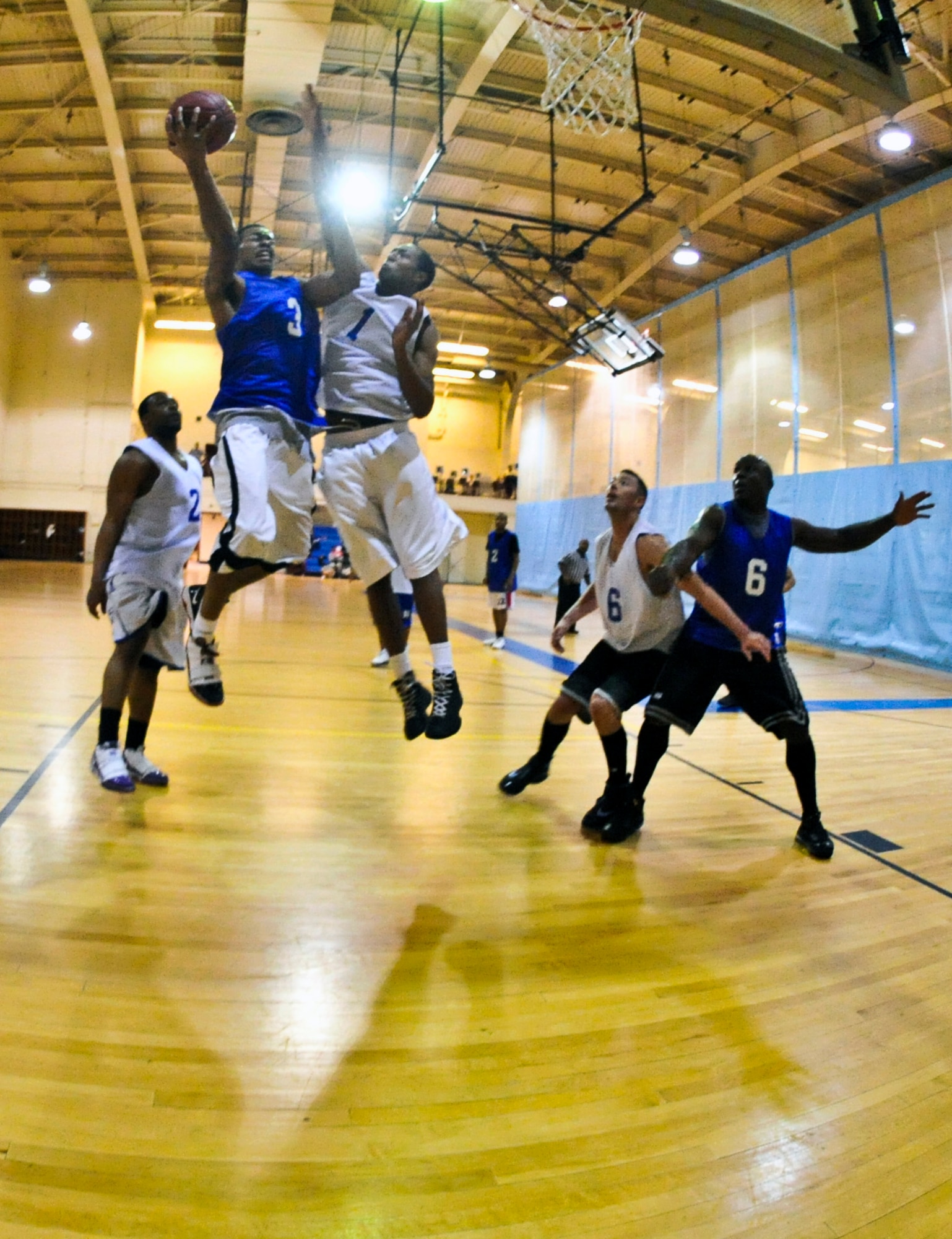 ELMENDORF AIR FORCE BASE, Alaska – A member from the 525th Fighter Squadron shoots past the Coast Guards Trevor Smith during a playoff game Jan. 14. The CG won with the score of 66-64. (Air Force photo by Airman 1st Class Christopher Gross)