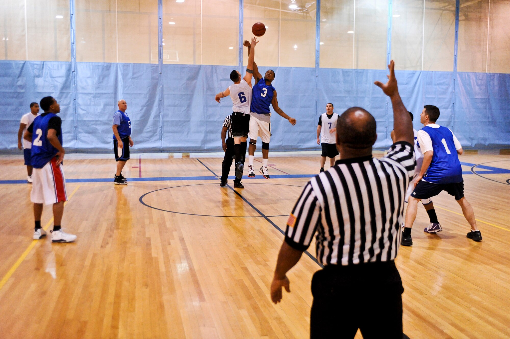 ELMENDORF AIR FORCE BASE, Alaska – Stevo Kelly, from the Coast Guard, white, and a member from the 525th Fighter Squadron jump for the ball to start a playoff game Jan. 14. The CG won with the score of 66-64. (Air Force photo by Airman 1st Class Christopher Gross)