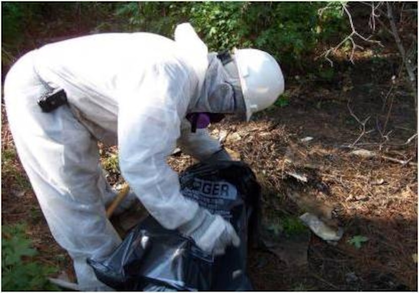 MOODY AIR FORCE BASE, Ga. -- A contractor removes asbestos from contaminated soil at a site discovered at Moody in 2005. During the suppression of a wildfire that year, workers came across multiple 55-gallon drums and metal buckets suspected of originally containing paint, pesticides and fuel. Asbestos removal is required before any on-site remediation can occur. (Contributed photo)