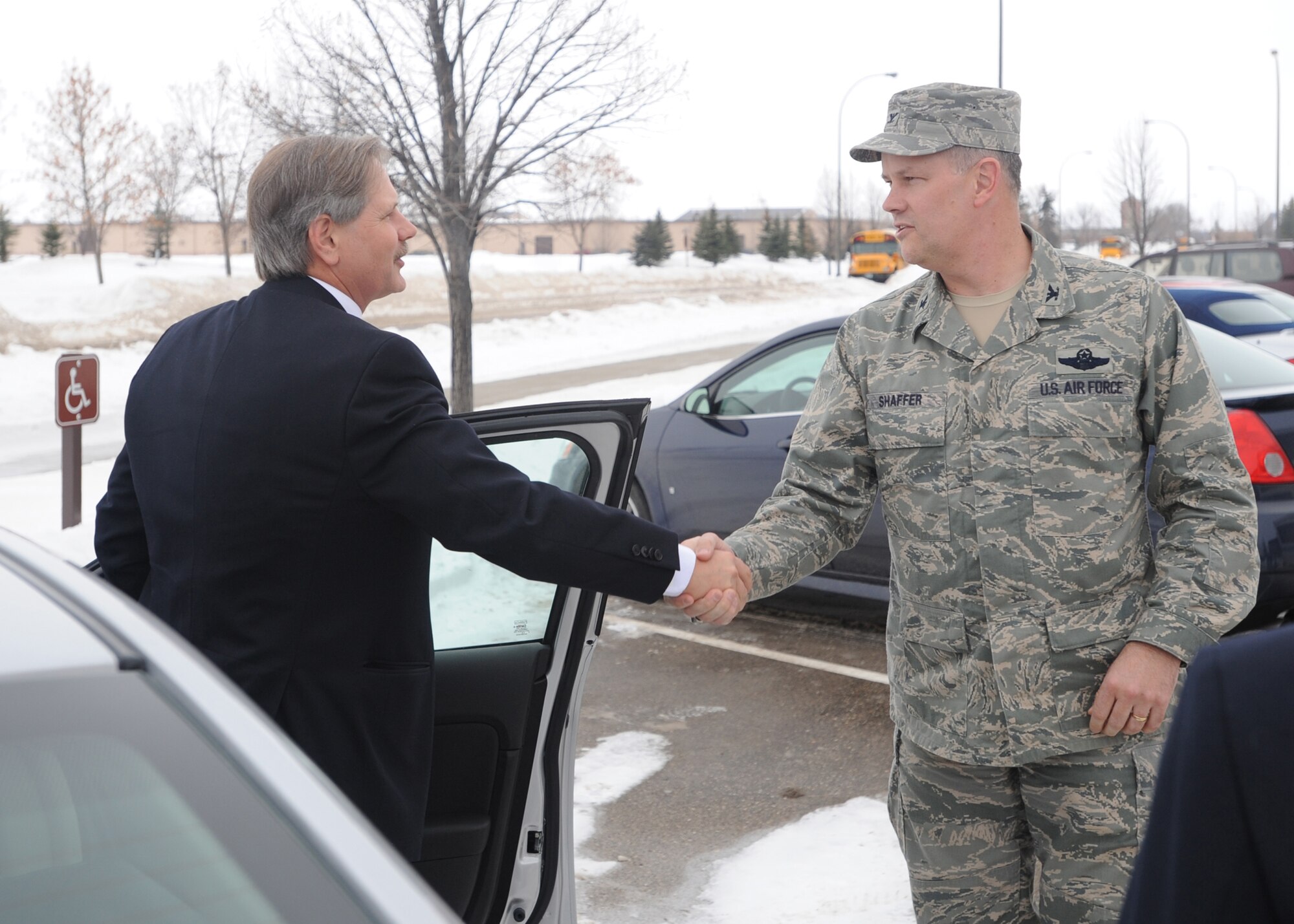 Col. Don Shaffer (right), 319th Air Refueling Wing commander, greets North Dakota governor, John Hoeven (left), upon his arrival at Grand Forks Air Force Base for Governor Appreciation Day, Jan. 14. (U.S. Air Force Photo by Staff Sgt. Suellyn Nuckolls)