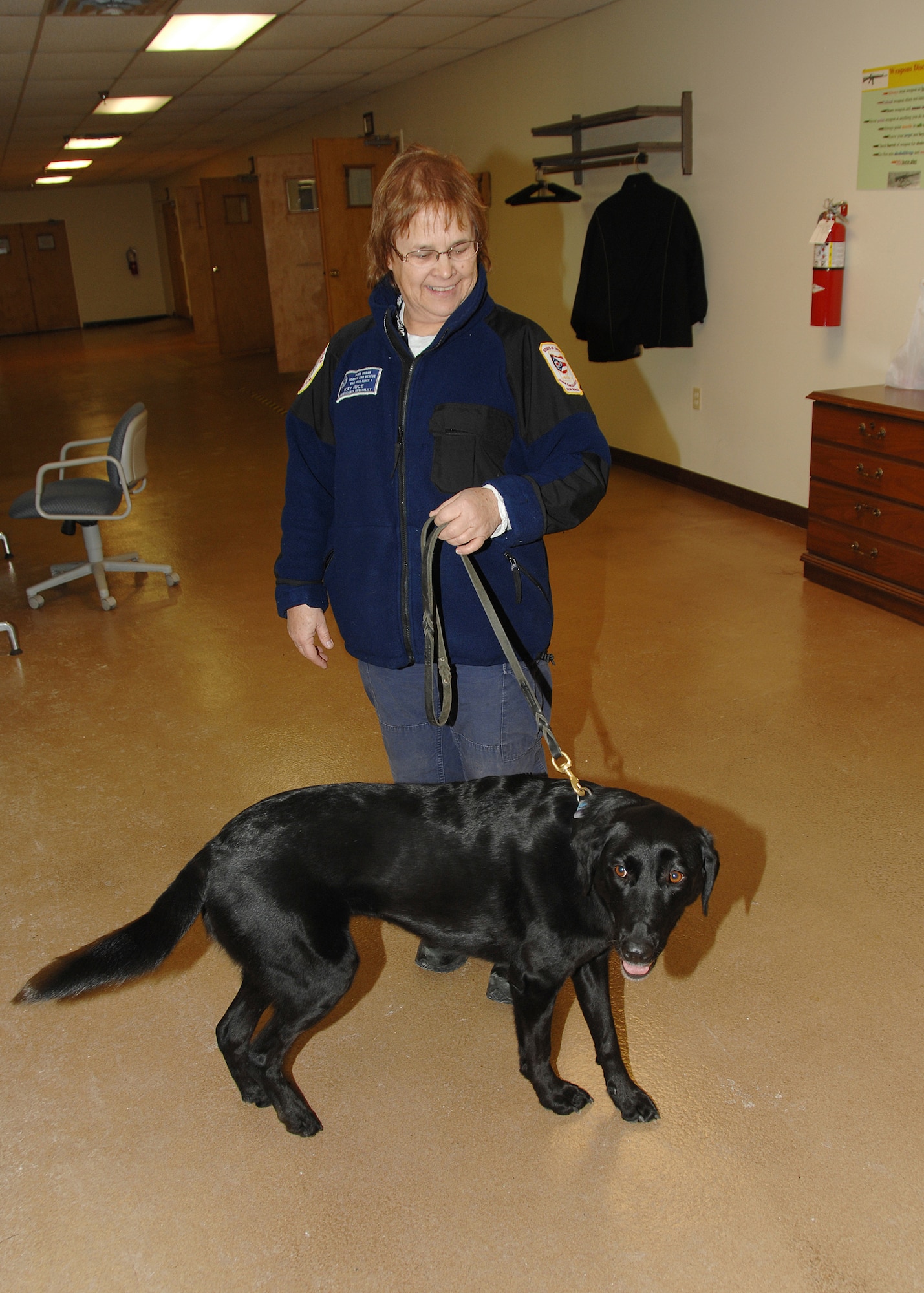 Ms. Kay Rice and her search and rescue-trained Labrador Retriever, Jazz, members of Ohio Task Force One, stretch their legs at the Wright-Patterson AFB Deployment Center while awaiting airlift to Haiti to provide humanitarian and disaster relief support in response to the recent earthquake.  The FEMA task force, made up of approximately 80 first-responders from across the Miami Valley and their equipment, is staging at Wright-Patterson AFB. The team has a total of six dogs deploying for this mission.  (AF Photo by Mr. Ben Strasser)