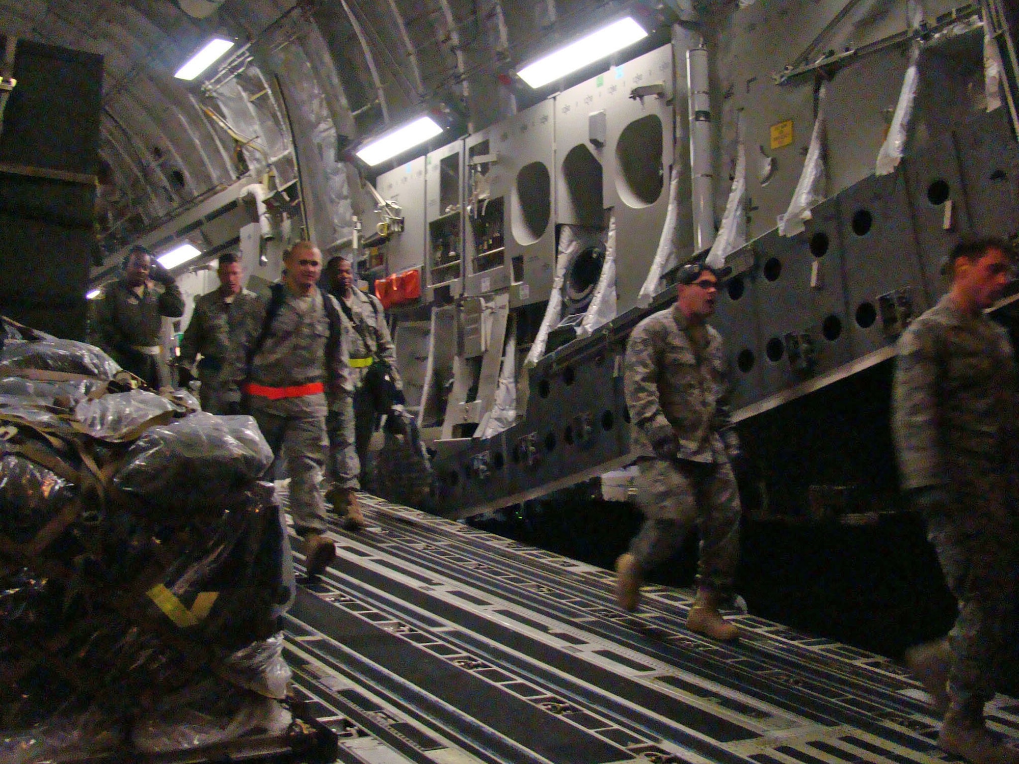 Members of the 621st Contingency Response Wing step down a C-17 Globemaster III cargo hatch Jan. 14, 2010, at the Toussaint L'Ouverture International Airport, Haiti. The 21 passengers and 44 tons of cargo were sent to Haiti on a 305th Air Mobility Wing C-17 from Joint Base McGuire-Dix-Lakehurst, N.J., to support relief operations in response to a devastating earthquake in the area. (U.S. Air Force photo/Tech. Sgt. Denise Johnson)
