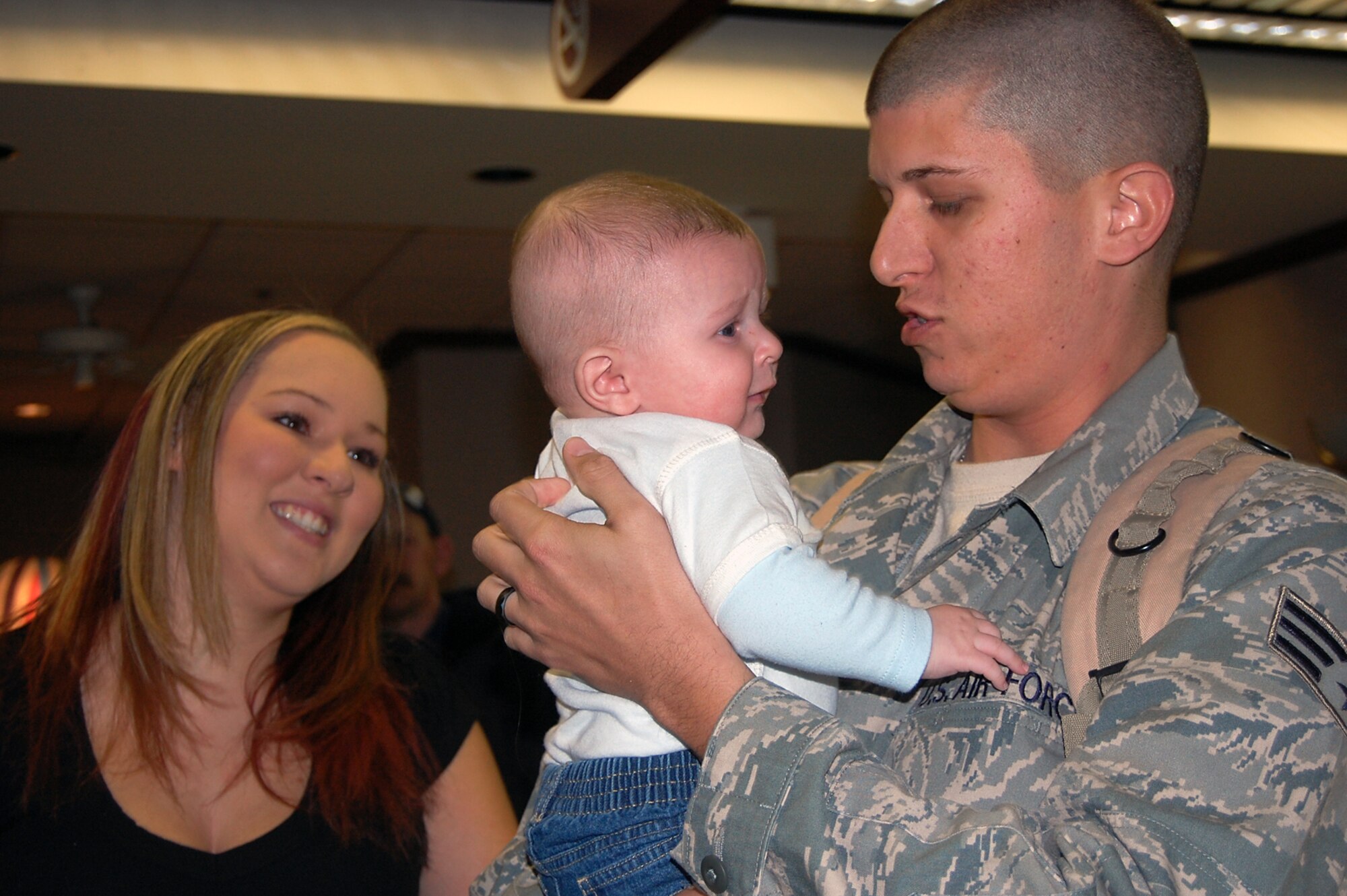 Senior Airman Joshua Jackson, from the 22nd Logistics Readiness Squadron Flight Services Center, McConnell Air Force Base, Kan., holds his 4-month-old, Kaden, for the first time, Jan. 6, 2010, at Mid-Continent Airport in Wichita, as his wife Tiffany stands alongside. Airman Jackson met Kaden after returning home from a six-month deployment to Southwest Asia. (U.S. Air Force photo/Staff Sgt. Amanda Currier)