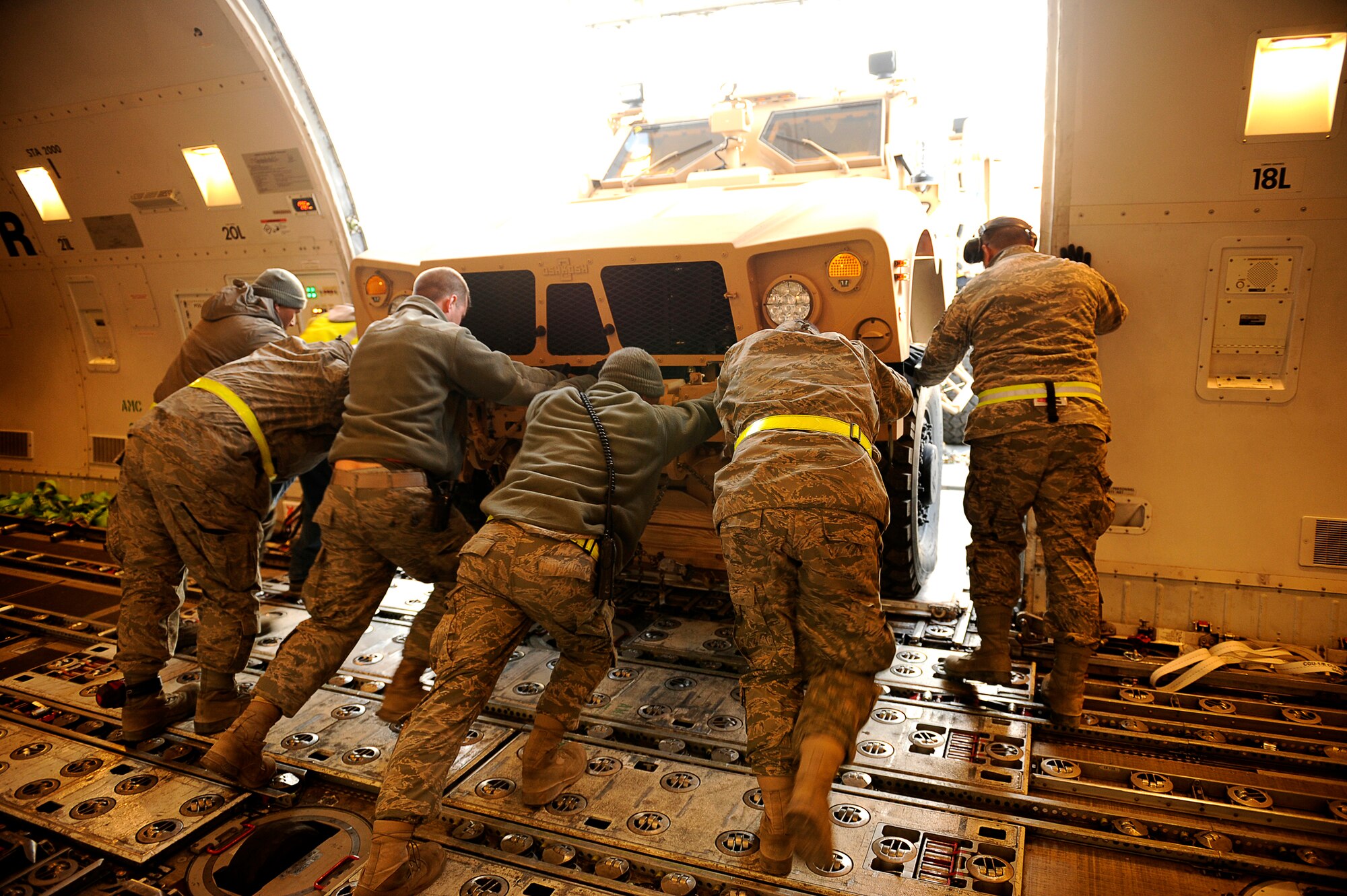 Airmen push a mine-resistant, ambush-protected all-terrain vehicle out of an aircraft Jan. 13, 2010 at Bagram Airfield, Afghanistan. The M-ATV is the latest combat vehicle used by U.S. combat forces. The Airmen are assigned to the from the 455th Expeditionary Aerial Port Squadron. (U.S. Air Force photo/Tech. Sgt. Jeromy K. Cross)
