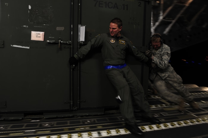 U.S. Air Force Technical Sgt. Robert Mabry, a reservist with the 317th, Airlift Squadron, 437th Air Mobility Wing, Charleston Air Force Base (AFB), S.C., pushes cargo with help from Airmanl from the 621st   Contingency Response Wing, Joint Base McGuire-Dix-Lakehurst, N.J., as they load cargo onto a Charleston AFB, C-17 Globemaster III, supporting a swift and coordinated relief effort to Haiti, Jan. 14, 2010, in the aftermath of a devastating earthquake.  (U.S. Air Force photo by Staff Sgt. Joshua L. DeMotts) (Released)