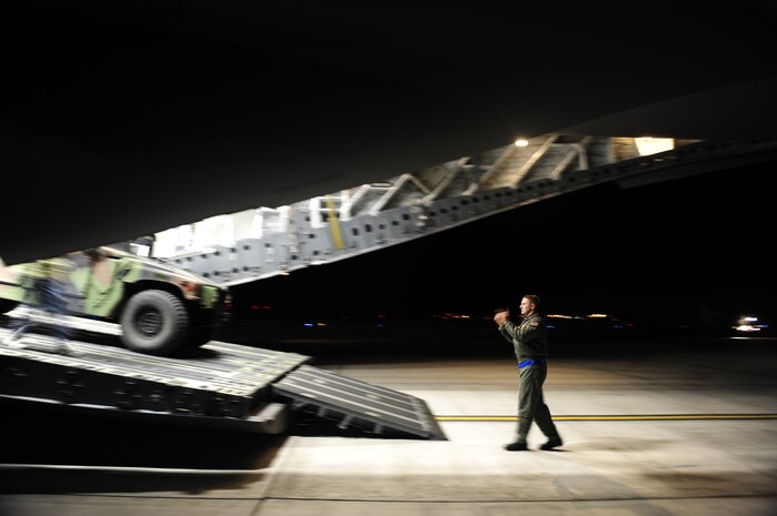 U.S.Air Force Technical Sgt. Robert Mabry a reservist from the 317th Airlift Squadron, 437th Air Mobility Wing, Charleston Air Force Base (AFB), S.C., directs a U.S. Air Force Humvee onto a Charleston AFB C-17 Globemaster III, on Joint Base McGuire-Dix-Lakehurst, N.J., in support of relief efforts to Haiti, Jan. 14, 2010 in the aftermath of a devastating earthquake.  (U.S. Air Force photo by Staff Sgt. Joshua L. DeMotts) (Released)