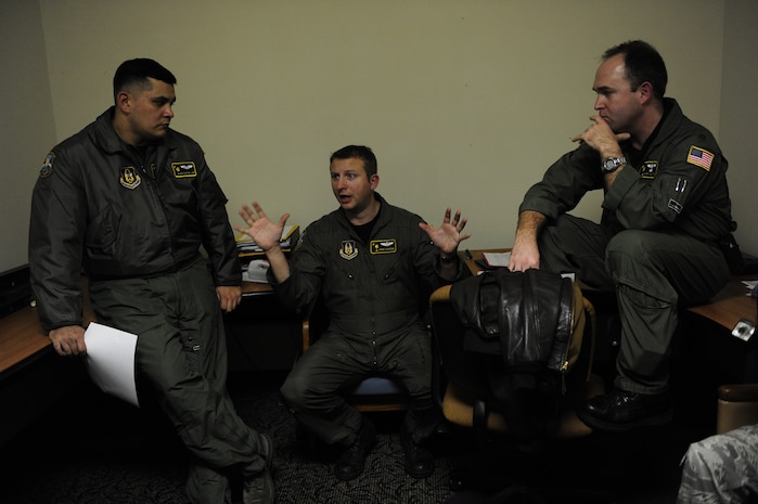 U.S.Air Force Reservists (from left to right) Master Sgt. Michael Lang, Maj. John Cousins, and Maj. Mark Smith with the 317th Airlift Squadron, 437th Air Mobility Wing, Charleston Air Force Base, S.C., conduct a crew brief prior to participating in a swift and coordinated relief effort to Haiti, Jan.14,2010, in the aftermath of a devastating earthquake.  (U.S. Air Force photo by Staff Sgt. Joshua L. DeMotts) (Released)