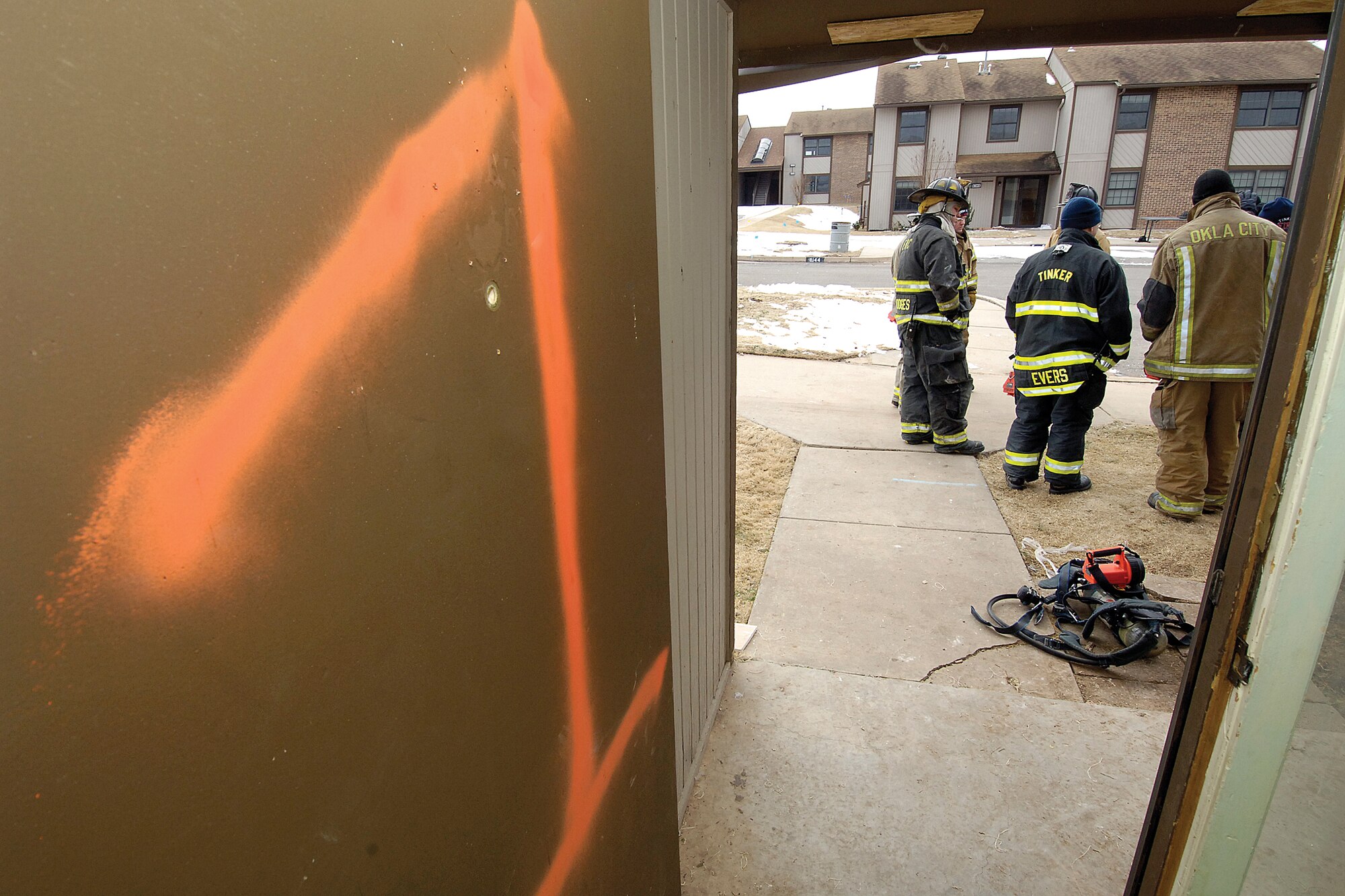 Tinker and Oklahoma City fire department instructors have a final planning walk around Jan. 4 before the first Tinker base housing apartment would be set ablaze during a live-fire training event. The apartments offered a rare opportunity for the departments to experience a week of fire fighting where rolling dense smoke and heat made the tightly controlled training as real as it gets. (Air Force photos by Margo Wright)