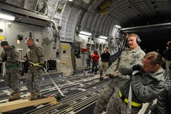 Members of the 305th Aerial Port Squadron load a mobile command and control unit onto C-17 Joint Base McGuire-Dix-Lakehurst, New Jersey, Jan. 15, 2010. Air Mobility Command is responding with all necessary forces and equipment to aide the humanitarian efforts in Haiti. (U.S. Air Force photo/Senior Airman Katie Gieratz)
