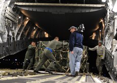 Airmen load equipment onto a Charleston C-17 at Joint Base McGuire-Dix-Lakehurst, New Jersey, Jan. 15, 2010. The Charleston C-17 was used to transport equipment needed to aid the humanitarian effort in Haiti. (U.S. Air Force photo/Senior Airman Katie Gieratz)