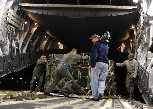 Airmen load equipment onto a Charleston C-17 at Joint Base McGuire-Dix-Lakehurst, New Jersey, Jan. 15, 2010. The Charleston C-17 was used to transport equipment needed to aid the humanitarian effort in Haiti. (U.S. Air Force photo/Senior Airman Katie Gieratz)(RELEASED)