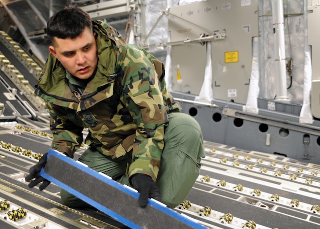 Master Sgt. Michael Lang flips the roll bars on a Charleston C-17 at Joint Base McGuire-Dix-Lakehurst, New Jersey, Jan. 15, 2010. The Haiti-bound C-17 was loaded for humanitarian relief efforts. Air Mobility Command responded immediately to the disaster. (U.S. Air Force photo/Senior Airman Katie Gieratz)(RELEASED)