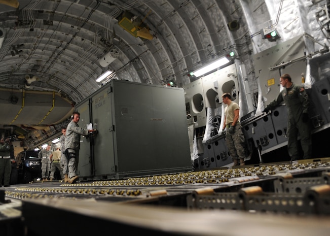 Equipment is unloaded from a Charleston AFB C-17 in Port-au-Prince, Haiti, Jan. 15, 2010. Air Mobility Command is assisting the humanitarian relief effort in Haiti by bringing the assets necessary to run airfield operations, air traffic control, command and control, aerial port, maintenance, and security. Additionally, AMC has aeromedical assets that can take care of and transport injured people to follow-on care. (U.S.Air Force photo/Senior Airman Katie Gieratz)(RELEASED)