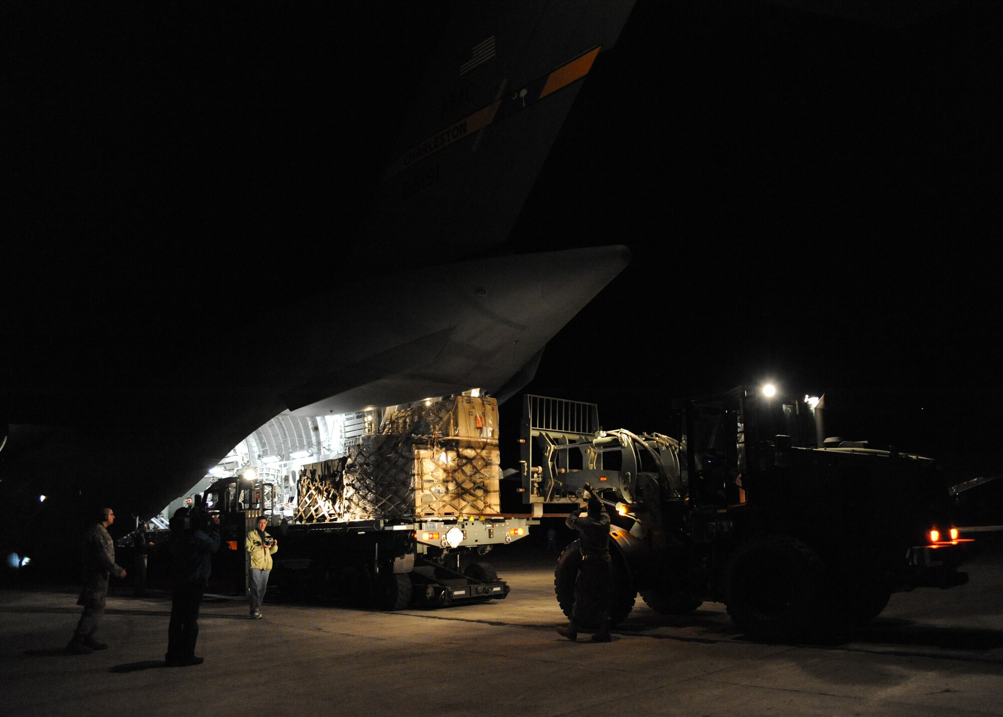 Equipment is unloaded from a Charleston AFB C-17 in Port-au-Prince, Haiti, Jan. 15, 2010. Air Mobility Command is assisting the humanitarian relief effort in Haiti by bringing the assets necessary to run airfield operations, air traffic control, command and control, aerial port, maintenance, and security. Additionally AMC has aeromedical assets that can take care of and transport injured people to follow-on care. (U.S.Air Force photo/Senior Airman Katie Gieratz)(RELEASED)