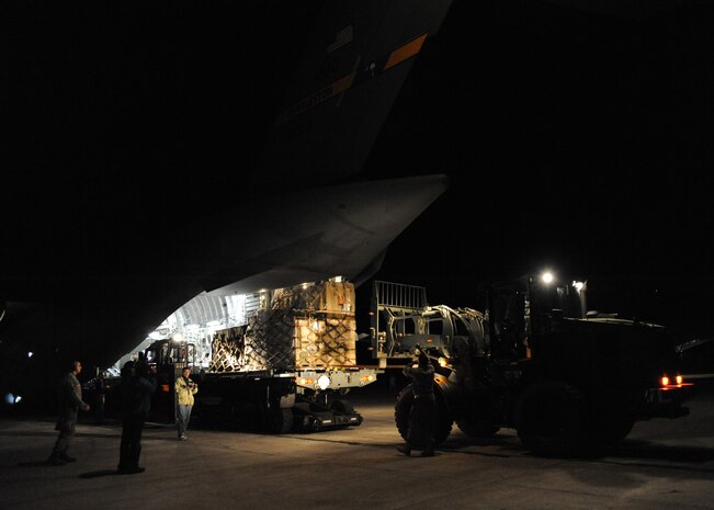 Equipment is unloaded from a Charleston AFB C-17 in Port-au-Prince, Haiti, Jan. 15, 2010. Air Mobility Command is assisting the humanitarian relief effort in Haiti by bringing the assets necessary to run airfield operations, air traffic control, command and control, aerial port, maintenance, and security. Additionally AMC has aeromedical assets that can take care of and transport injured people to follow-on care. (U.S.Air Force photo/Senior Airman Katie Gieratz)(RELEASED)