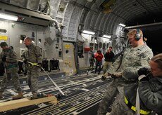 Members of the 305th Aerial Port Squadron load equipment onto C-17 at Joint Base McGuire-Dix-Lakehurst, New Jersey, Jan. 15, 2010. Air Mobility Command is responding with all necessary forces and equipment to aide the humanitarian efforts in Haiti. (U.S. Air Force photo/Senior Airman Katie Gieratz)(RELEASED)