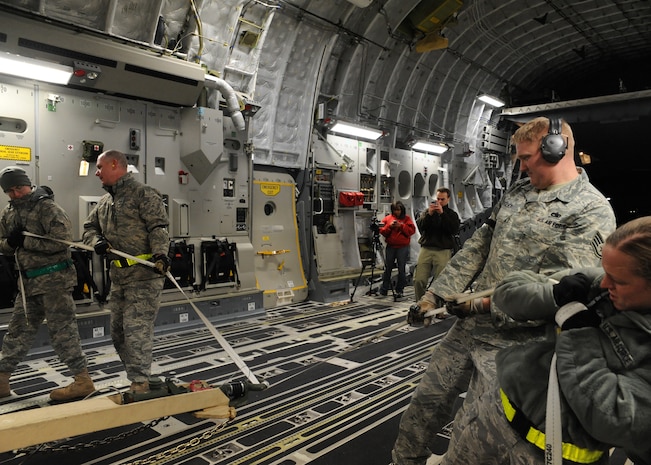 Members of the 305th Aerial Port Squadron load equipment onto C-17 at Joint Base McGuire-Dix-Lakehurst, New Jersey, Jan. 15, 2010. Air Mobility Command is responding with all necessary forces and equipment to aide the humanitarian efforts in Haiti. (U.S. Air Force photo/Senior Airman Katie Gieratz)(RELEASED)