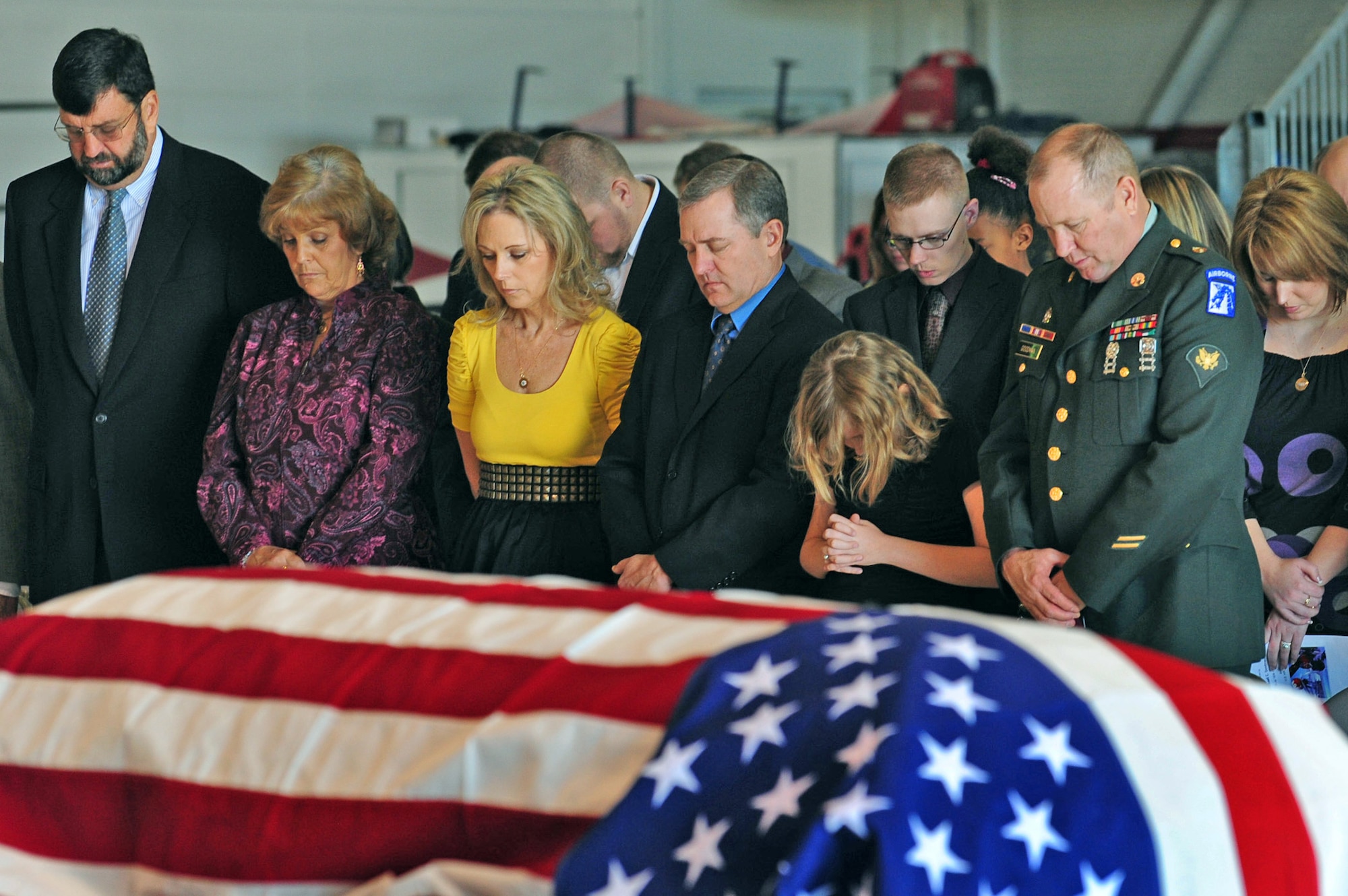 Friends and family of Maj. Russell Goodman pray during the funeral service held inside the Thunderbird hanger Jan. 14, 2010, at Nellis Air Force Base, Nev. Major Goodman served as the narrator for the Air Force Thunderbirds from 1964 to 1965 and was declared missing in action after his aircraft was hit by a surface-to-air missile in February 1967 while on a combat mission over North Vietnam. (U.S. Air Force photo/Staff Sgt. William P. Coleman) 