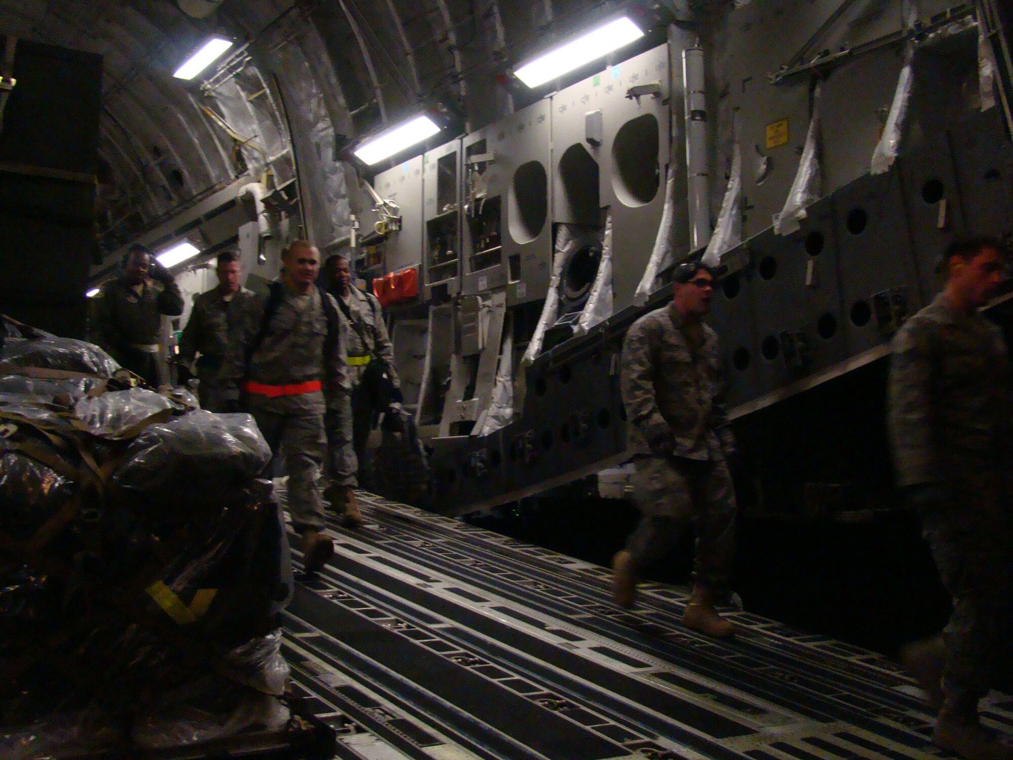 PORT AU PRINCE, Haiti -- Members of the 621st CRW here step down a C-17 cargo hatch at the Toussaint Louverture International Airport, Haiti, Jan. 14. The 21 passengers squeezed in among 44 tons of cargo being sent to Haiti via a 305th Air Mobility Wing C-17 Globemaster III to support relief operations in response to a devastating earthquake in the area. (U.S. Air Force Photo by Tech. Sgt. Denise Johnson)