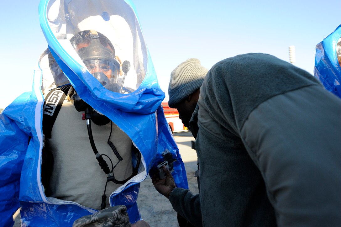 LANGLEY AIR FORCE BASE, Va. –Tech. Sgts. Michael Woodburn (left) and Leon Johnson (right), 633d Aerospace Medicine Squadron bioenvironmental technicians, ensure protective equipment is properly donned during a Chemical Biological Radiology Nuclear Challenge Jan. 14. The fifth annual CBRNE challenge is an exercise that tests the base’s hazardous incident response capabilities. (U.S. Air Force photo/ Senior Airman Dana Hill)