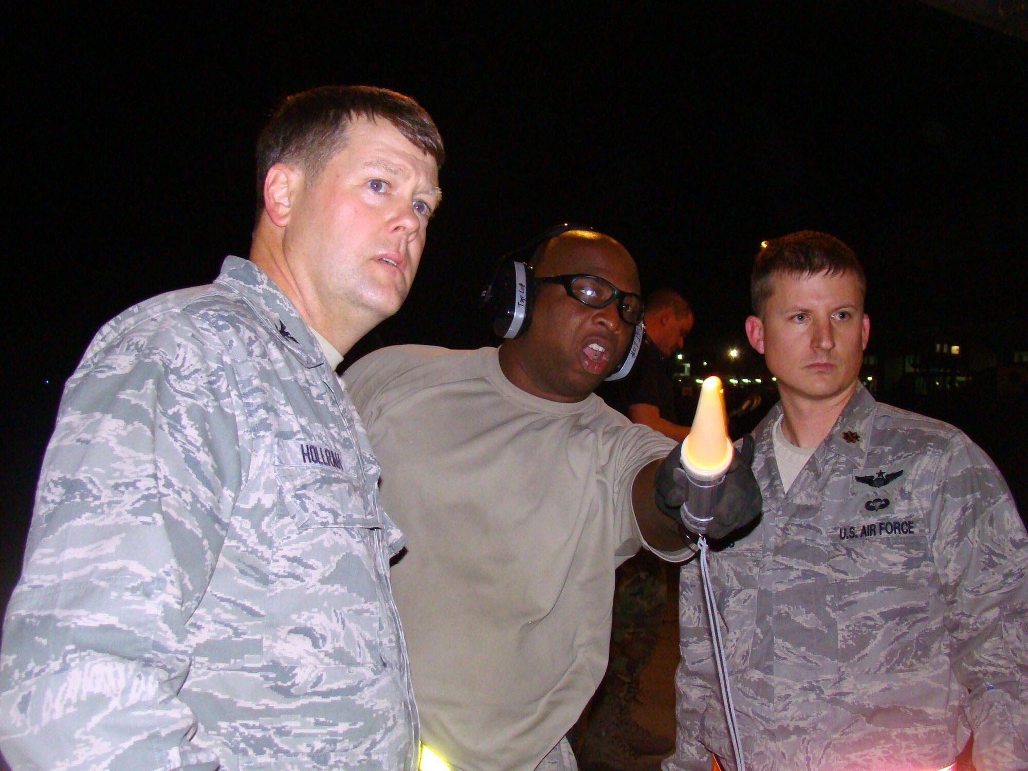 PORT AU PRINCE, Haiti -- Tech. Sgt. Charlie Lott points out landmarks on the flightline to Col. Hoot Hollrah, 817th Contingency Response Group commander and Maj. Matthew Jones, both of the 621st CRW at the Toussaint Louverture International Airport, Haiti, Jan. 14. Sergeant Lott is an air transportation specialist with the 1st Special Operations Logistics Readiness Squadron, Hurlburt Field, Fla. Colonel Hollrah and his team arrived in Haiti via a 305th Air Mobility Wing C-17 Globemaster III to support relief operations in response to a devastating earthquake in the area. (U.S. Air Force Photo by Tech. Sgt. Denise Johnson) 