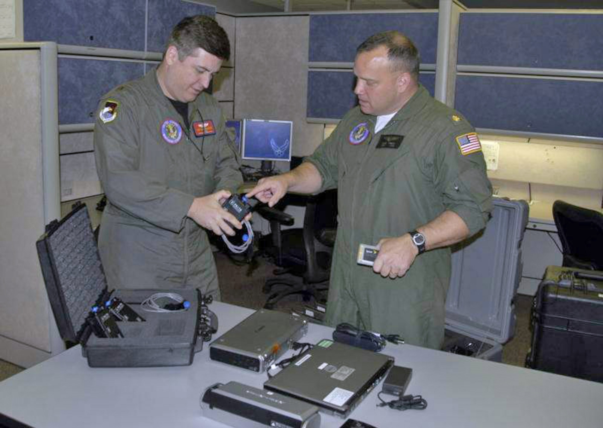 Maj. Jim Gallagher (left) and Navy Lt. Cmdr. Chris Arnett examine Blue Force Tracking devices in preparation for Commander Arnett's deployment in support of Haitian earthquake relief efforts Jan. 13, 2010, at Tyndall Air Force Base, Fla. (U.S. Air Force photo)