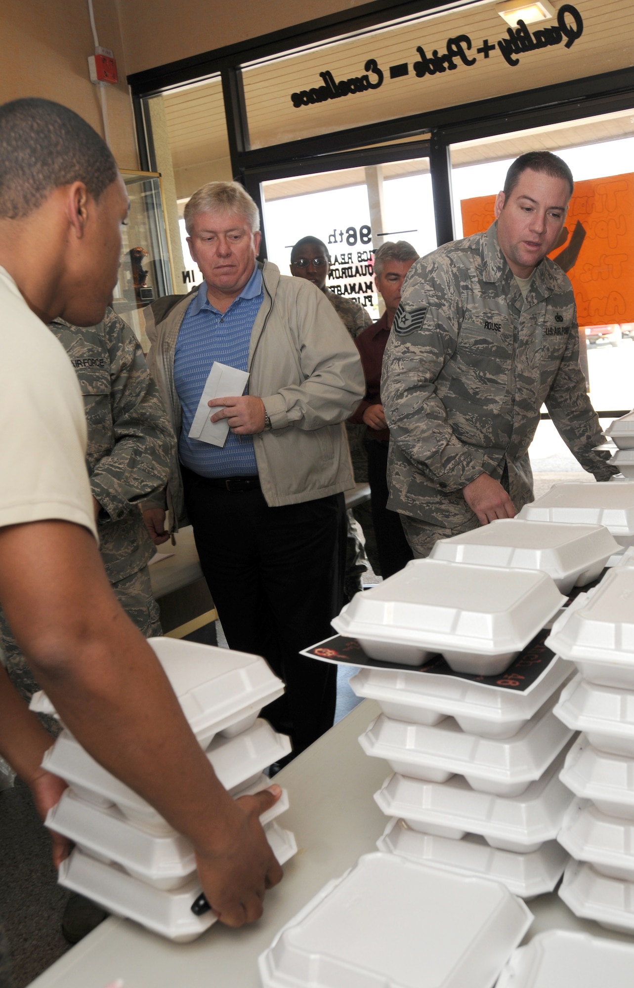 Tech. Sgt. Brent Rouse, 96th Logistics Readiness Squadron, helps carry out orders of pulled pork sandwiches for a fundraiser to raise monies for fellow a Airman. The proceeds raised will help offset additional costs the family is incurring while Tech. Sgt. Olafsen undergoes treatment to for leukemia at Sacred Heart Hospital in Pensacola, Fla. The  (U.S. Air Force photo/ Staff Sgt. Stacia Zachary)